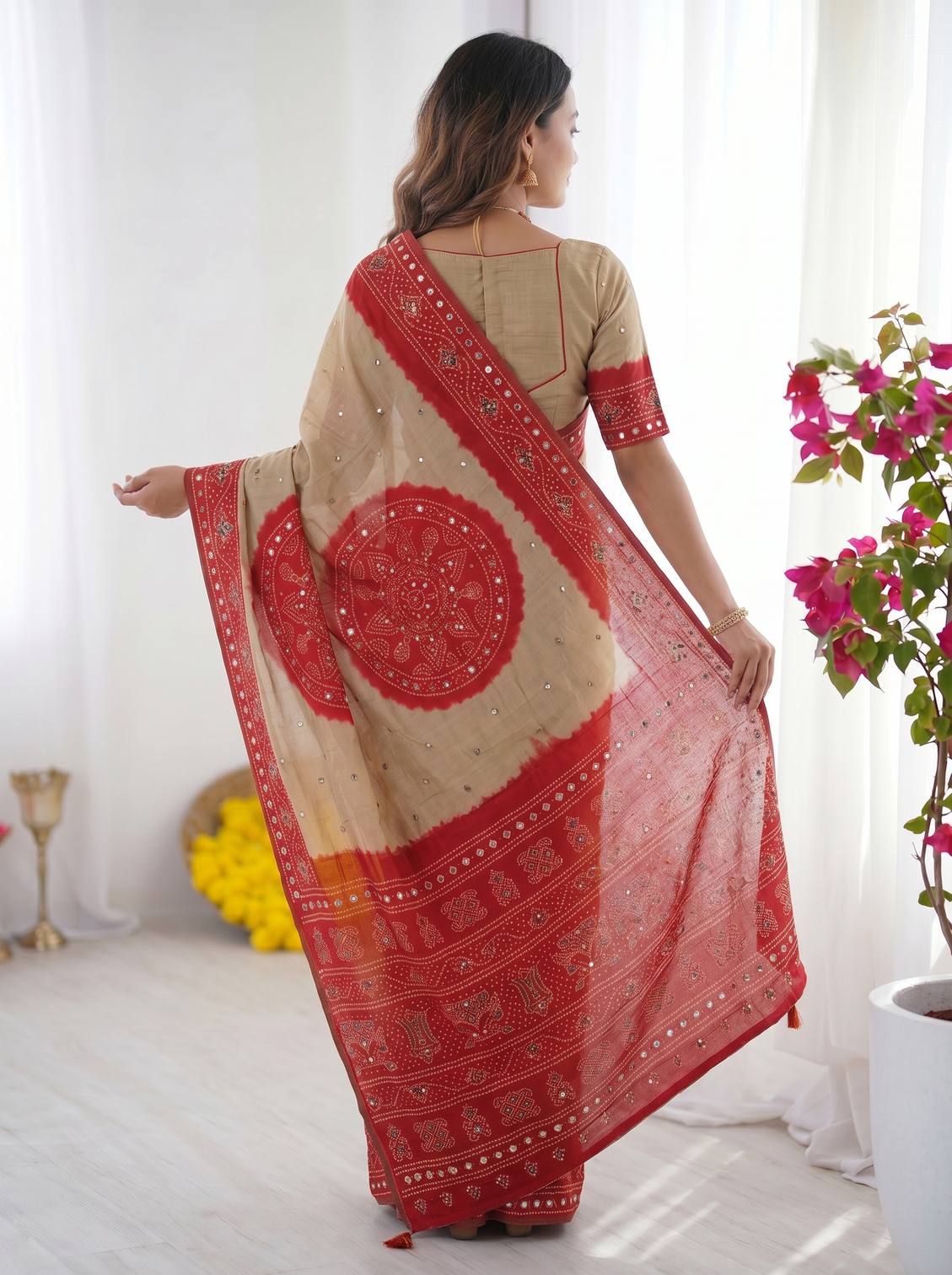 Beige crimson red bandhani inspired modal silk saree with traditional folk print pallu stone embellishments