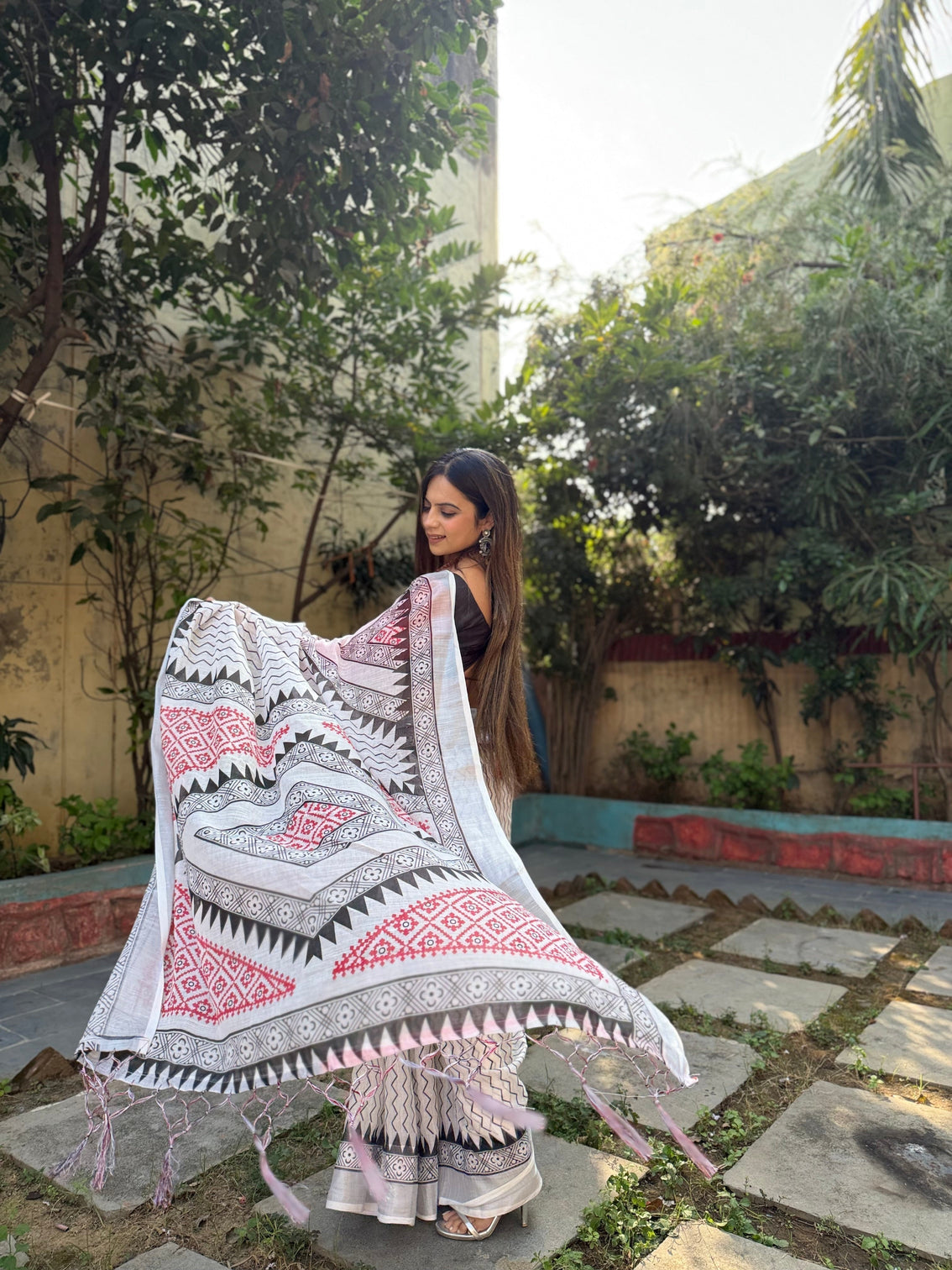 Elegant white pure linen digital printed saree with chevron design and intricate red black geometric pallu tassel details and matching blouse piece