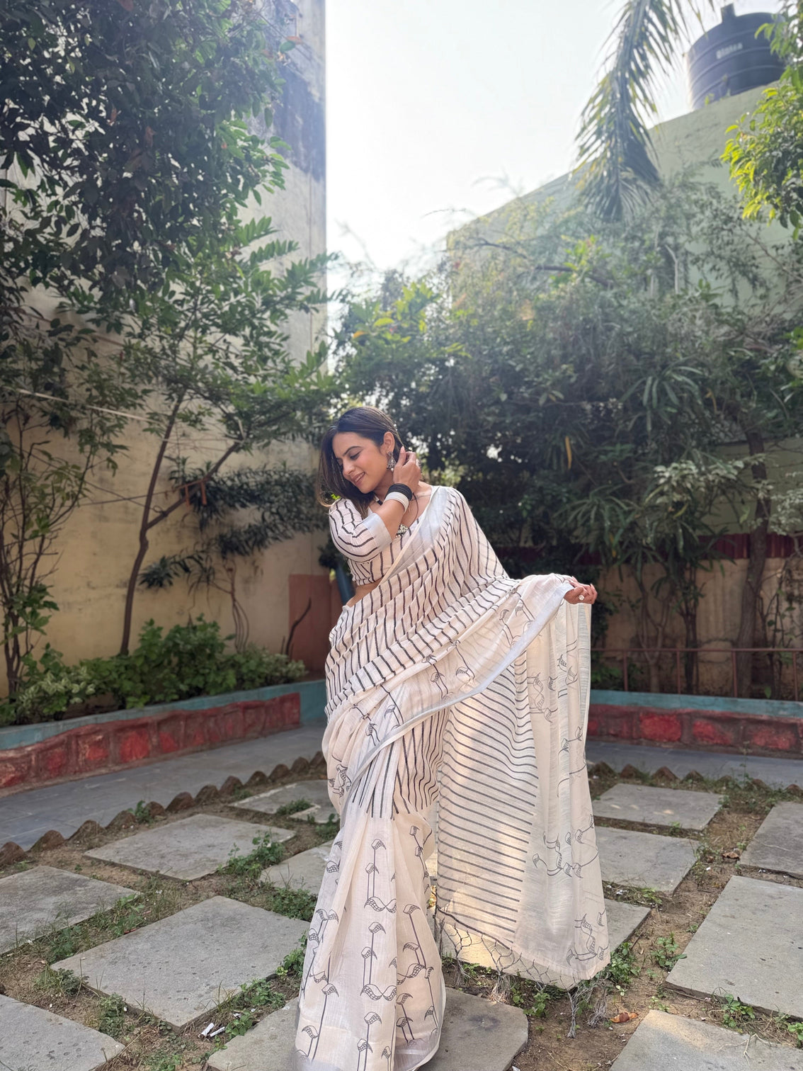Elegant off white pure linen digital printed saree with striped design and unique black motif pallu comes with blouse piece and tassels