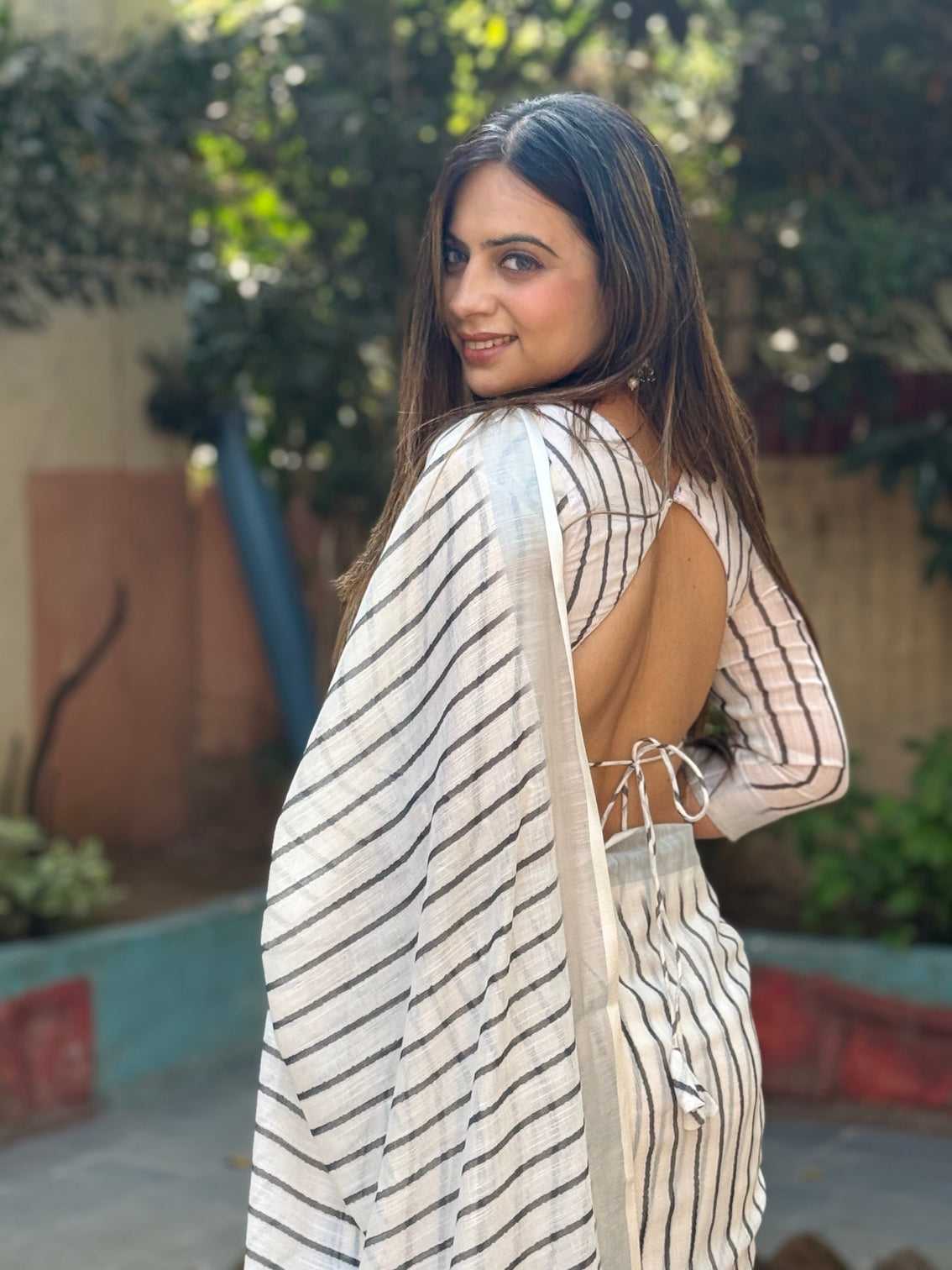 Elegant off white pure linen digital printed saree with striped design and unique black motif pallu comes with blouse piece and tassels