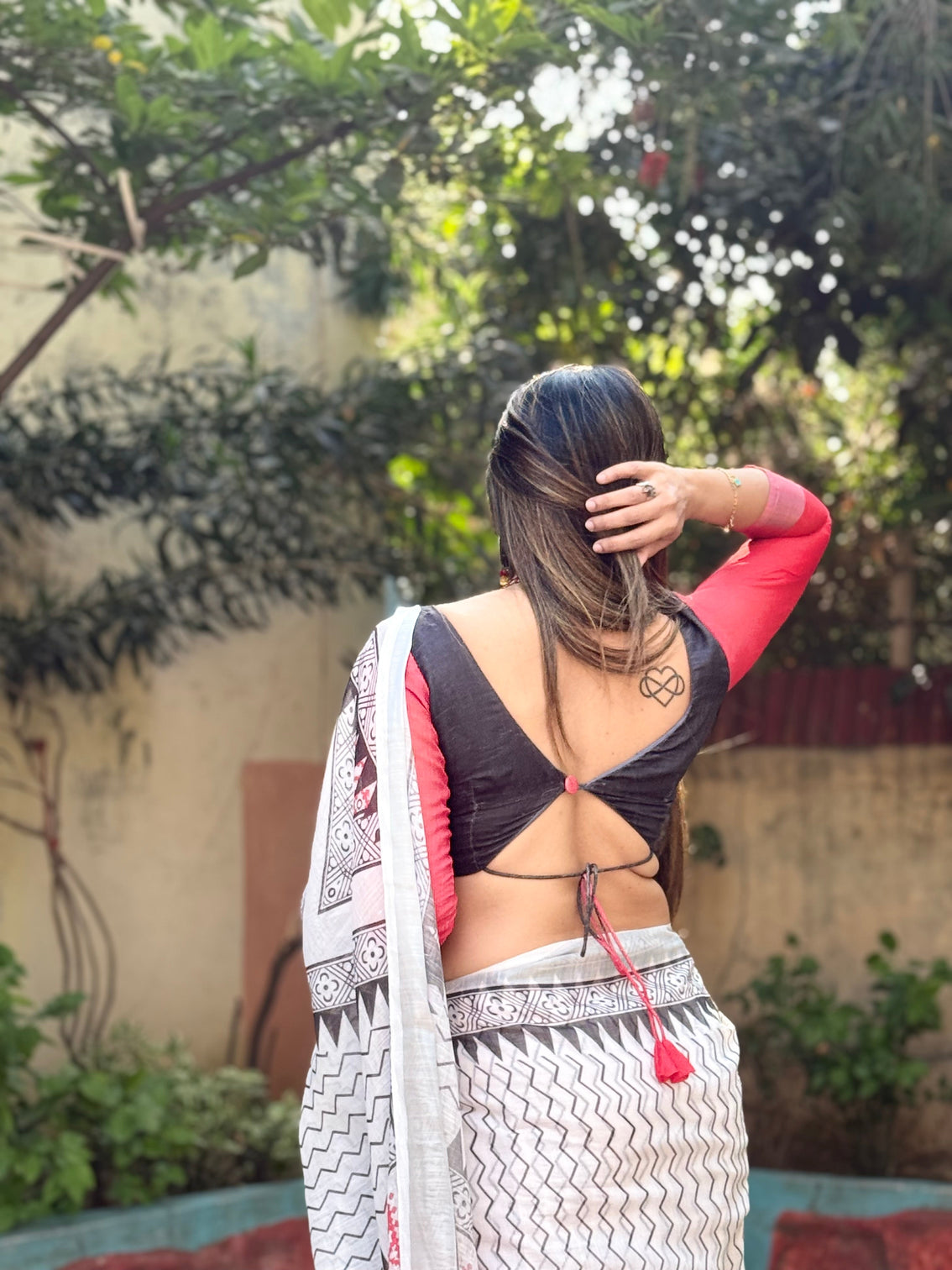 Elegant white pure linen digital printed saree with chevron design and intricate red black geometric pallu tassel details and matching blouse piece