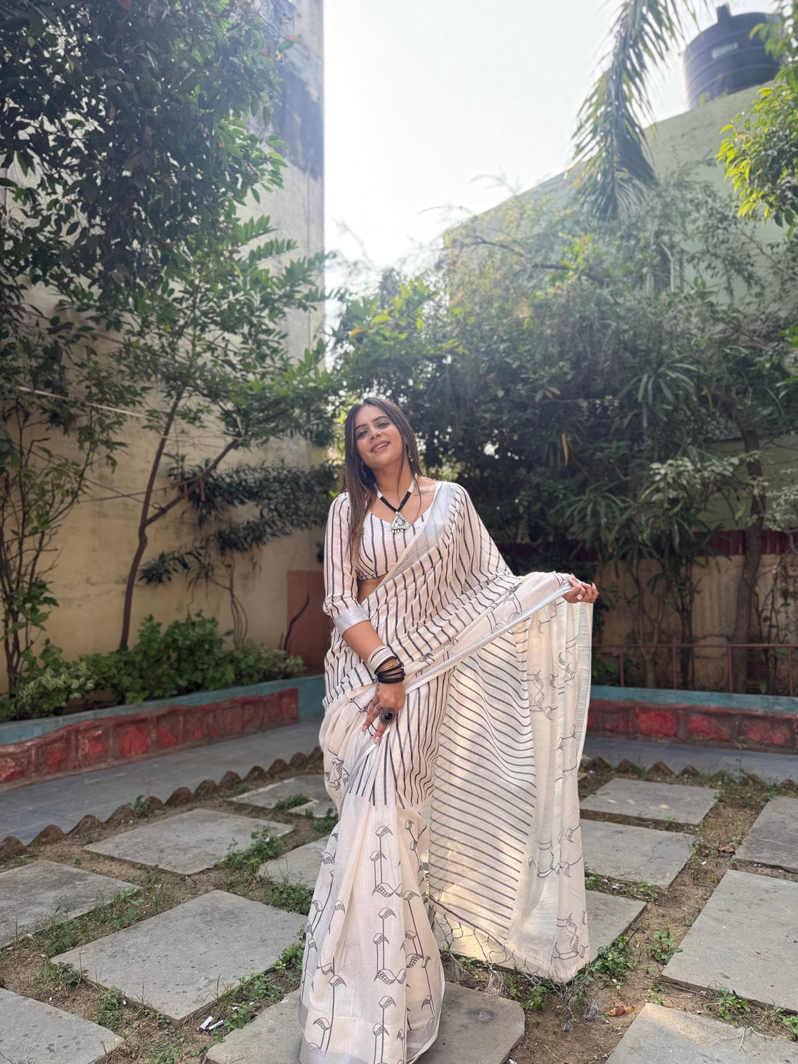Elegant off white pure linen digital printed saree with striped design and unique black motif pallu comes with blouse piece and tassels