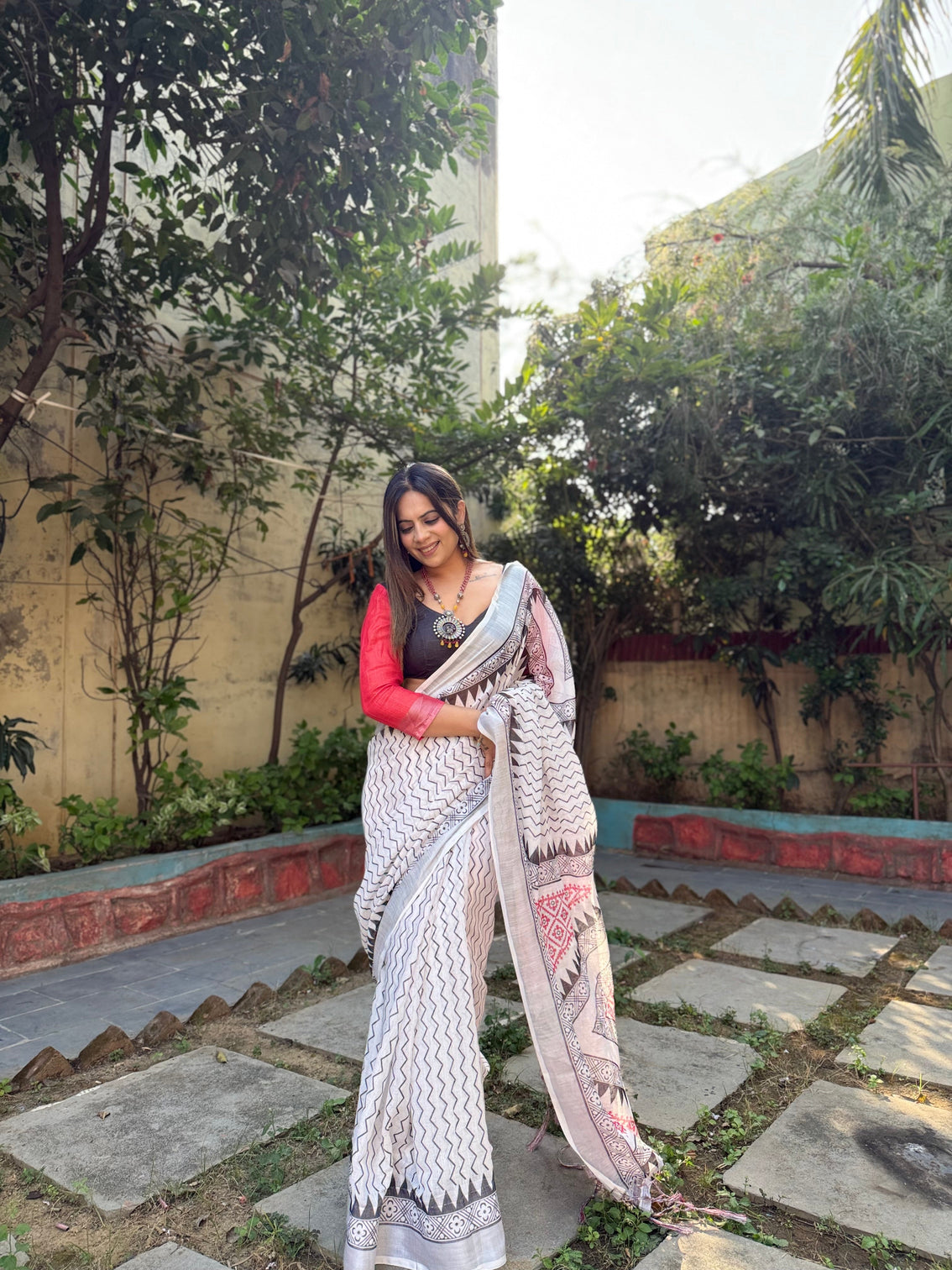 Elegant white pure linen digital printed saree with chevron design and intricate red black geometric pallu tassel details and matching blouse piece