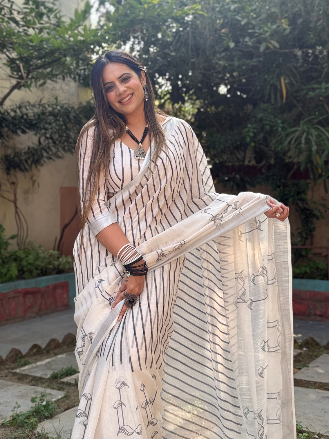 Elegant off white pure linen digital printed saree with striped design and unique black motif pallu comes with blouse piece and tassels mameraa