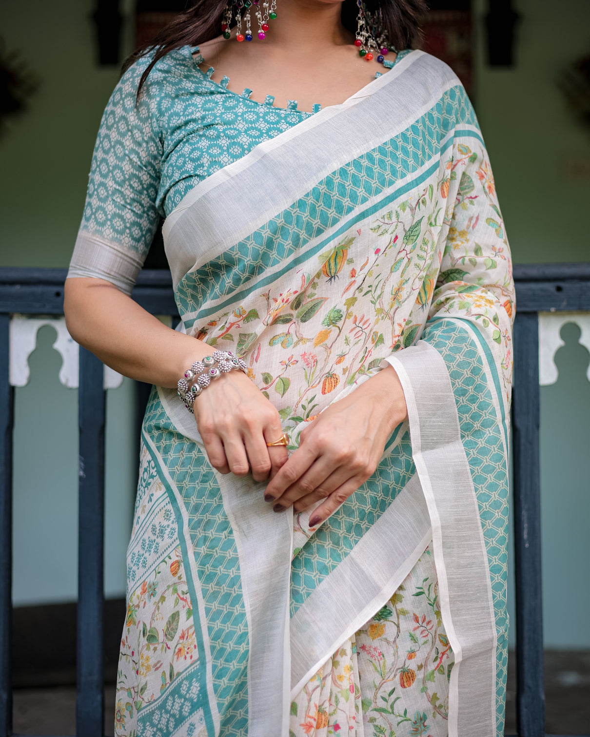 Elegant floral printed pure cotton linen saree in ivory with teal border and blouse tassels on edges