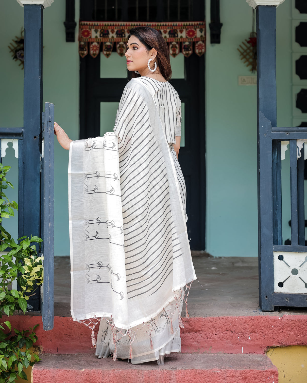 White and black pure cotton linen saree with striped pattern blouse and tassel detailing