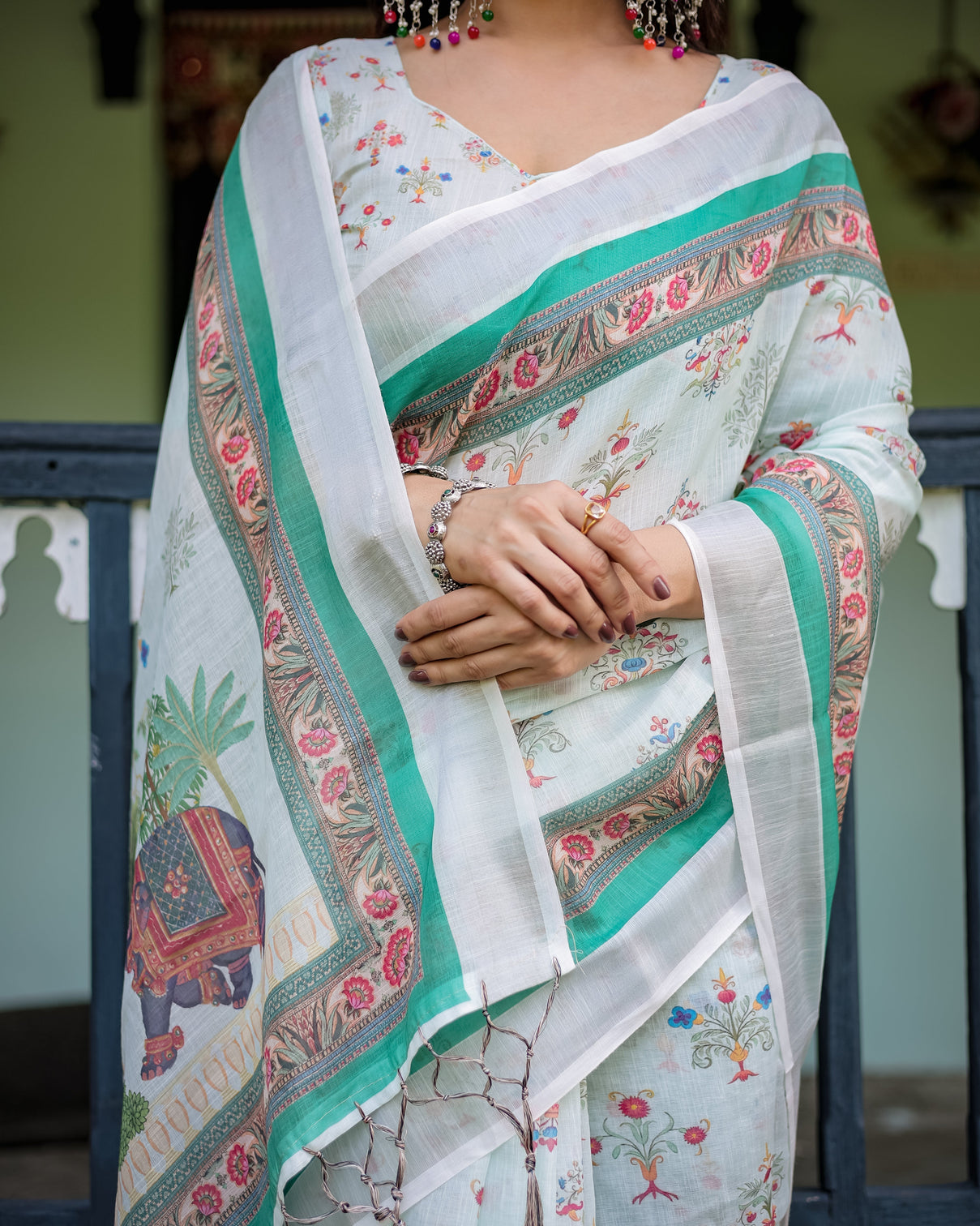 Ivory pure cotton linen saree with elephant motif and floral pattern green and pink borders and tassels on edges