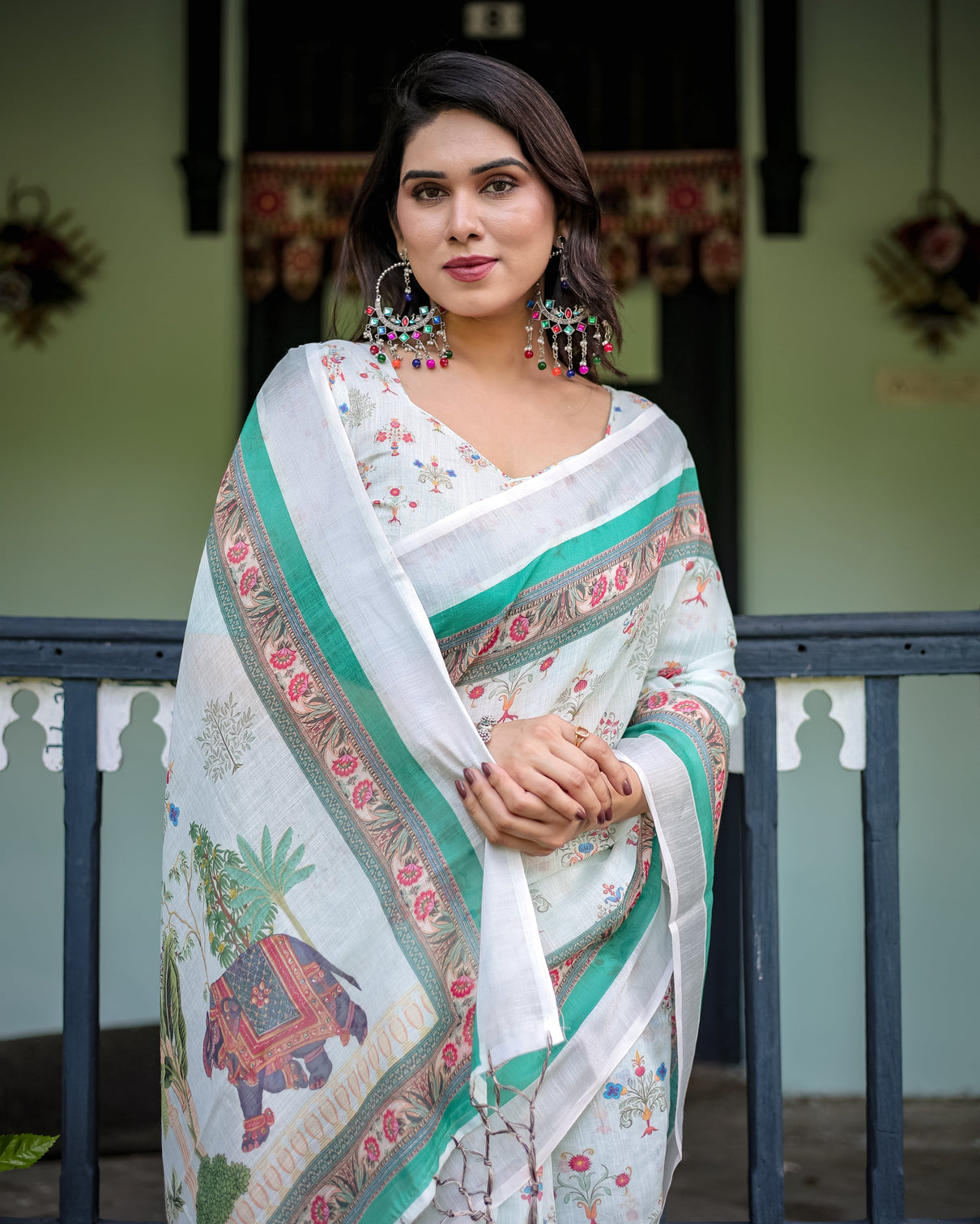Ivory pure cotton linen saree with elephant motif and floral pattern green and pink borders and tassels on edges