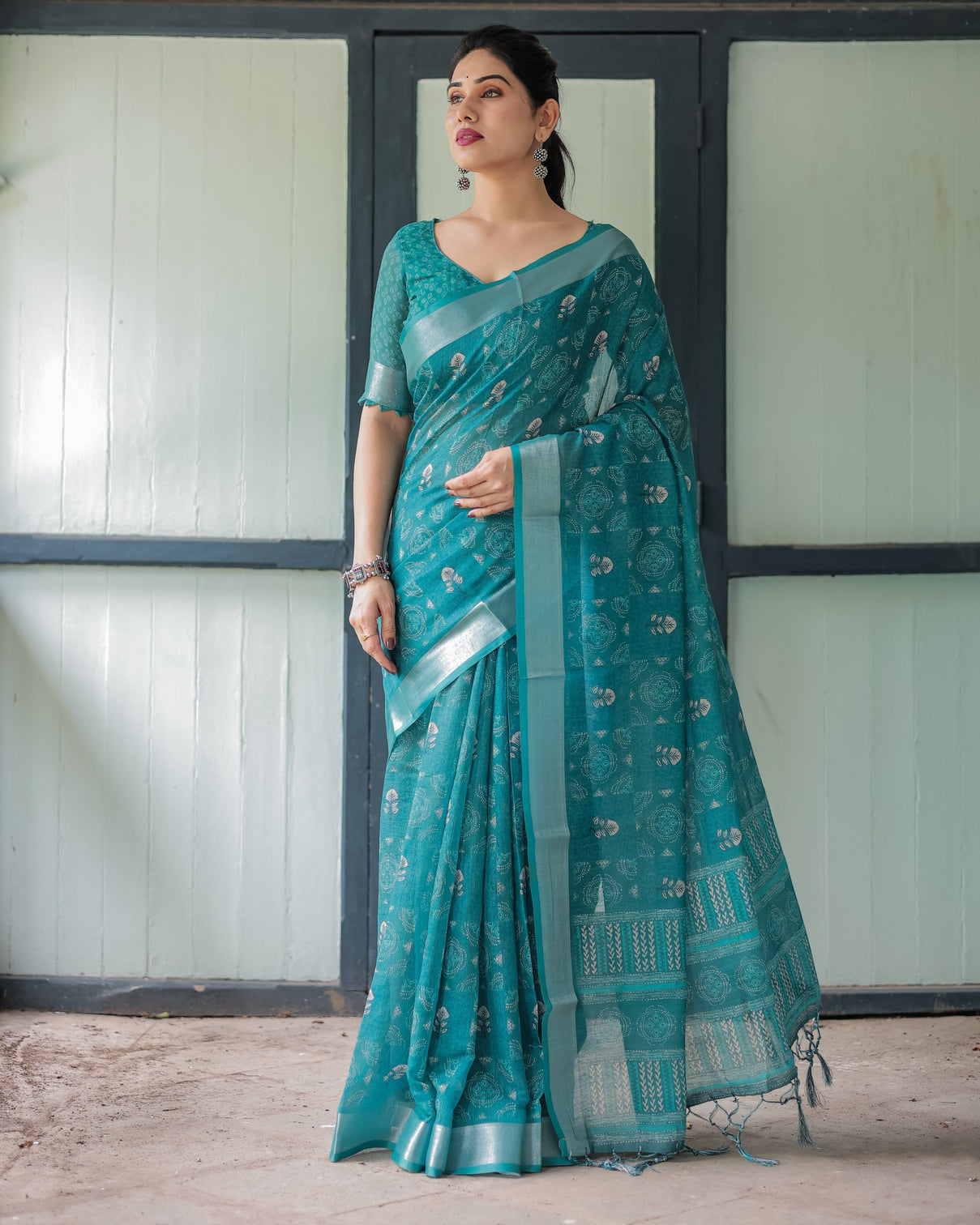 Teal green pure cotton linen saree with silver floral motifs and tassels