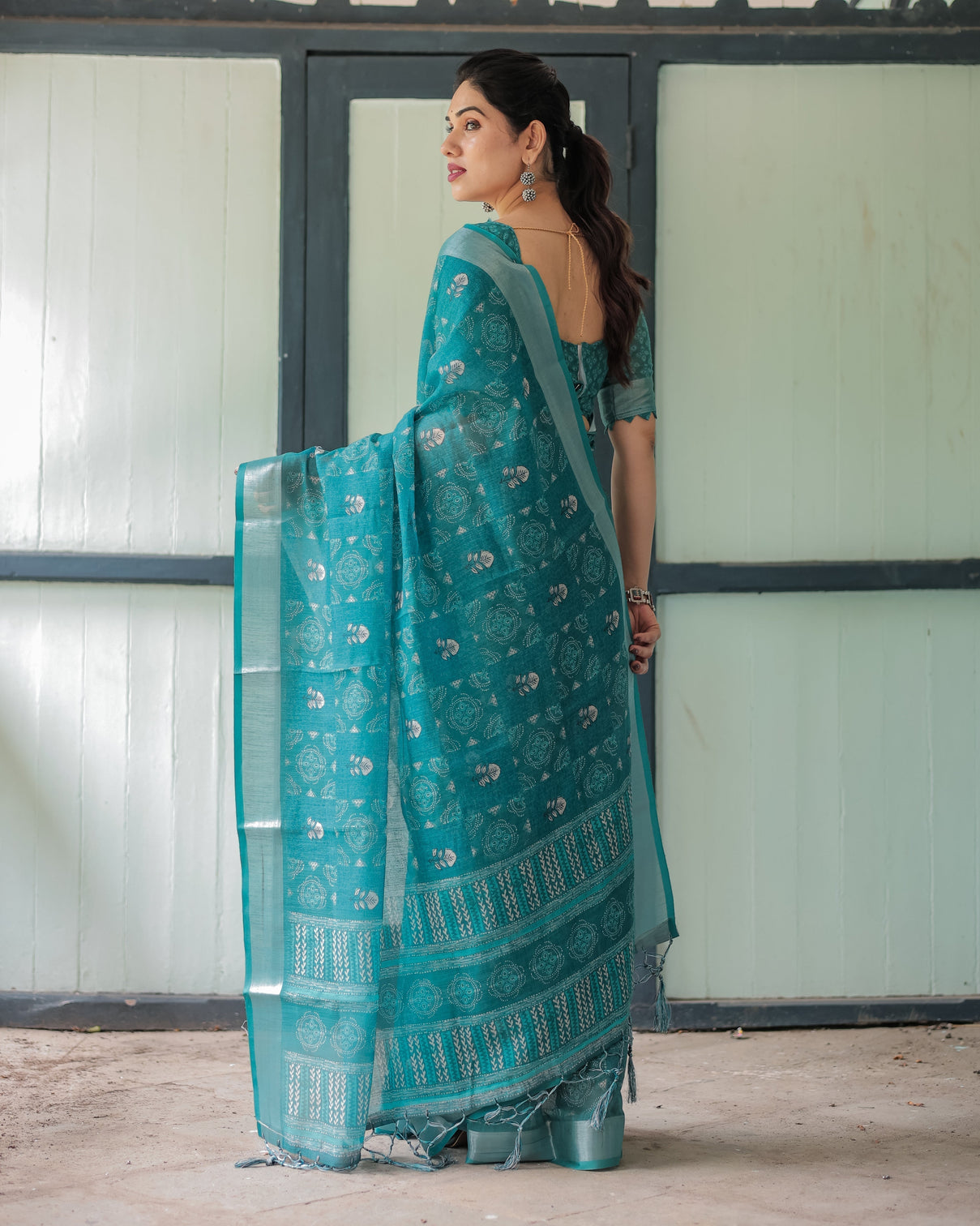 Teal green pure cotton linen saree with silver floral motifs and tassels
