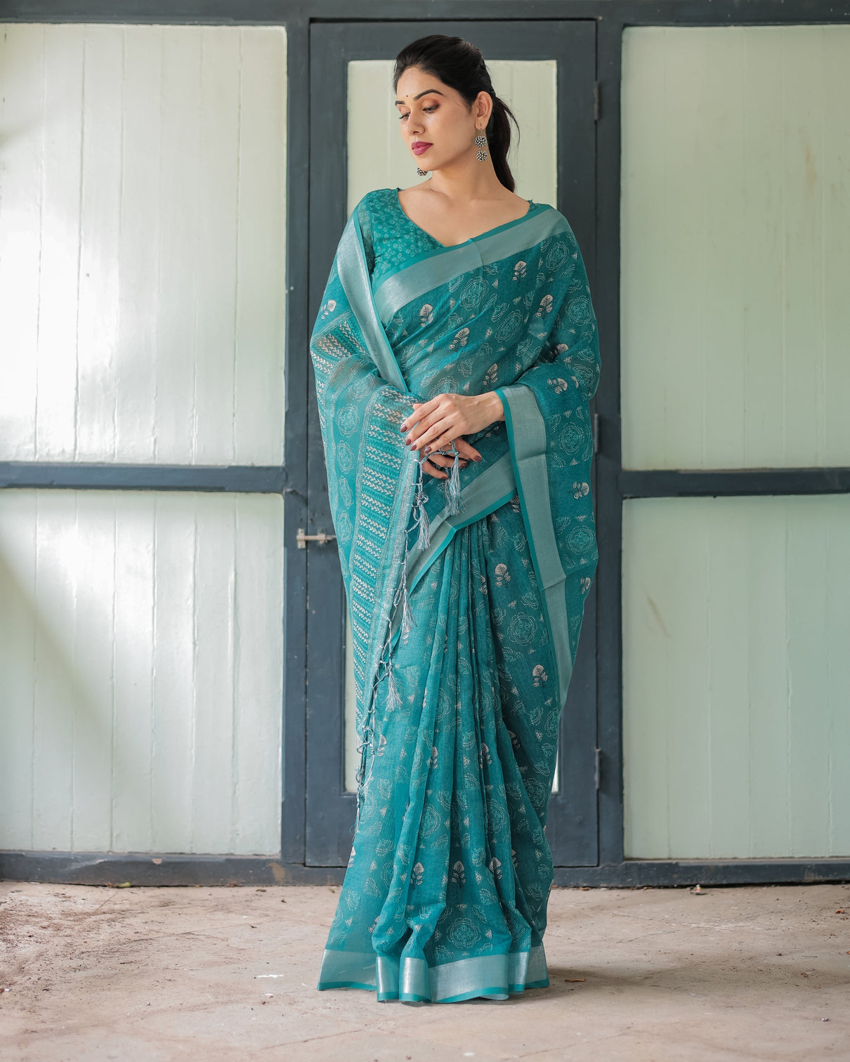 Teal green pure cotton linen saree with silver floral motifs and tassels