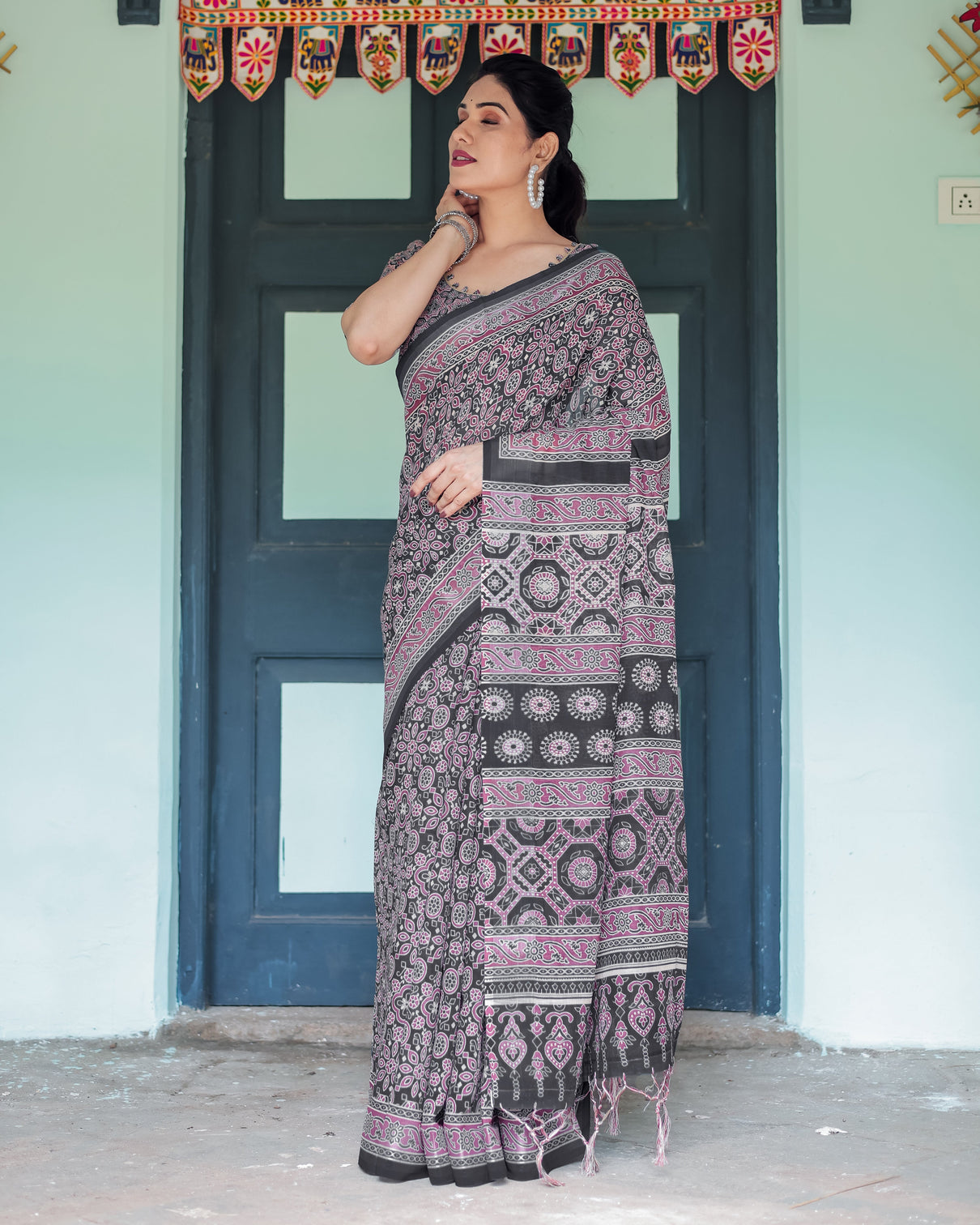 Black pure cotton linen saree with pink striped pallu and tassel accents