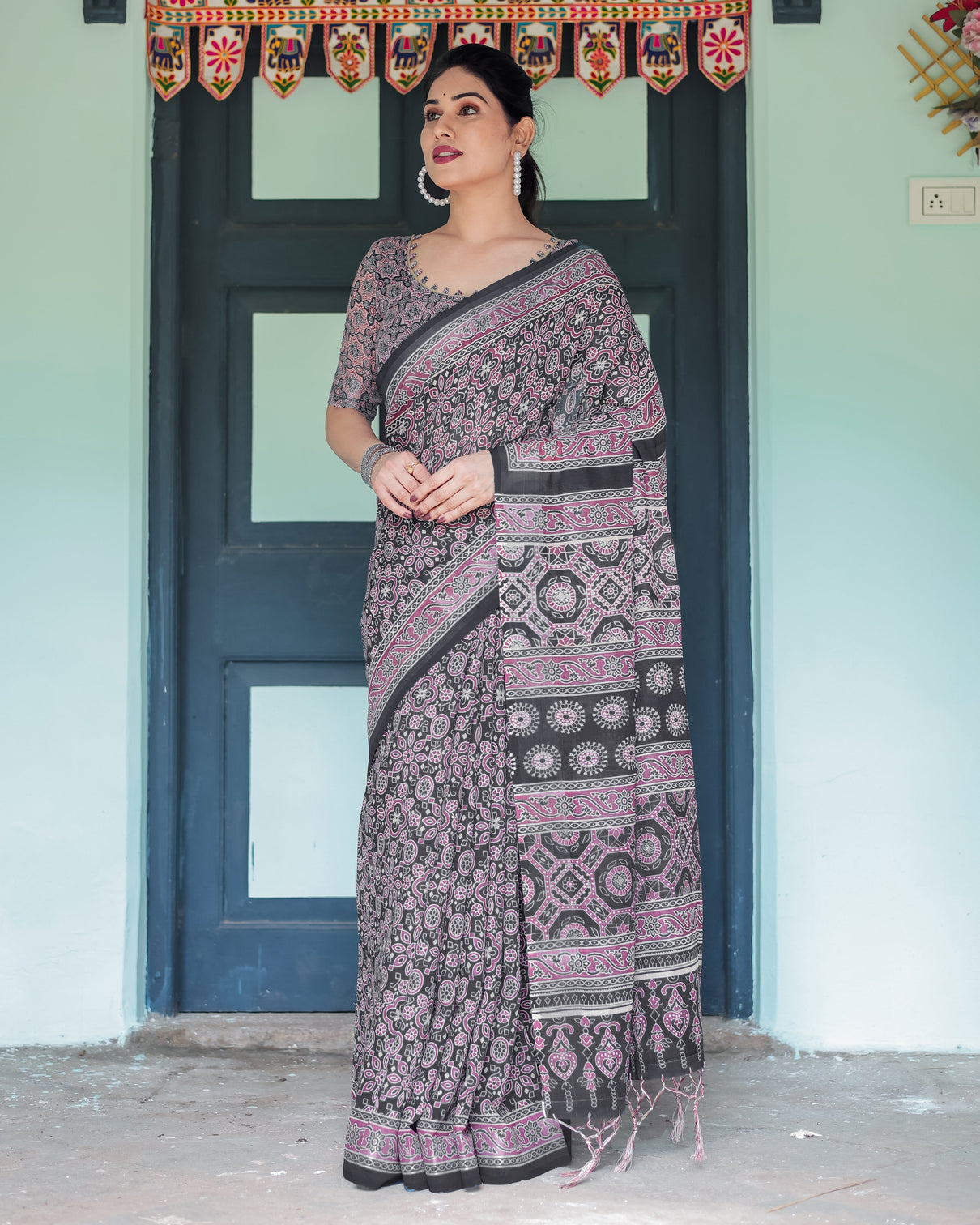 Black pure cotton linen saree with pink striped pallu and tassel accents