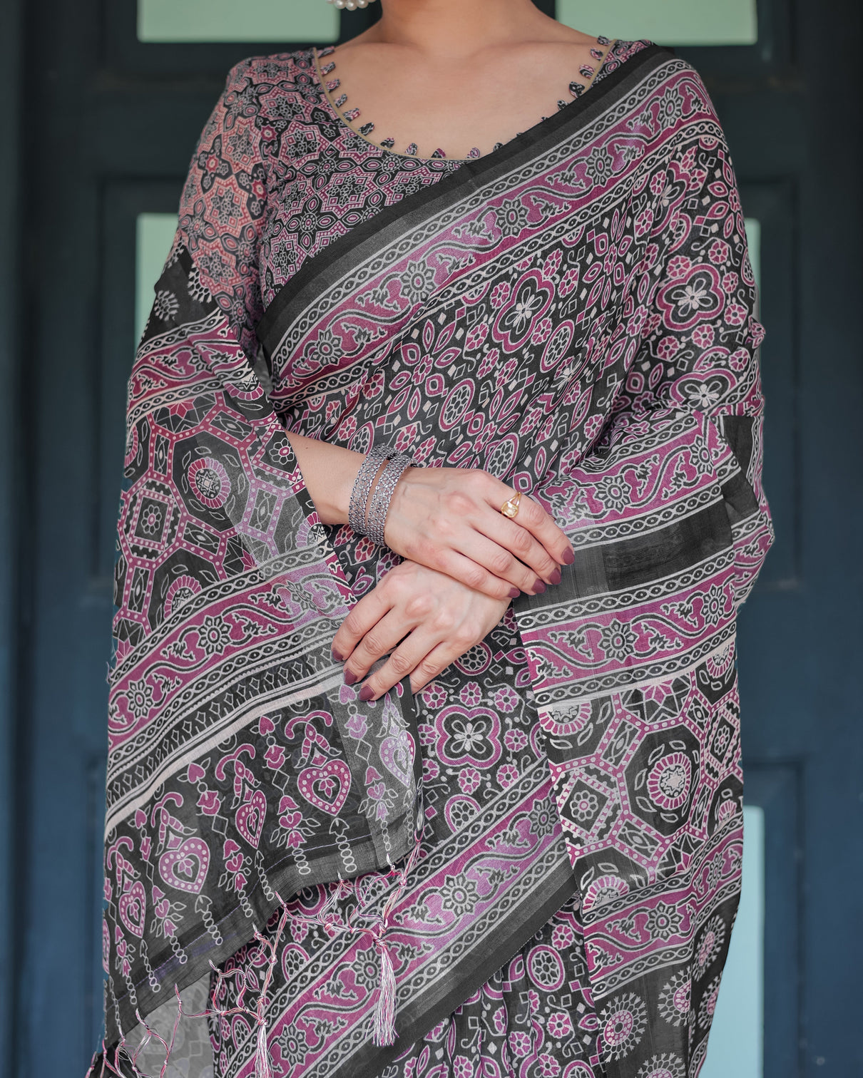 Black pure cotton linen saree with pink striped pallu and tassel accents