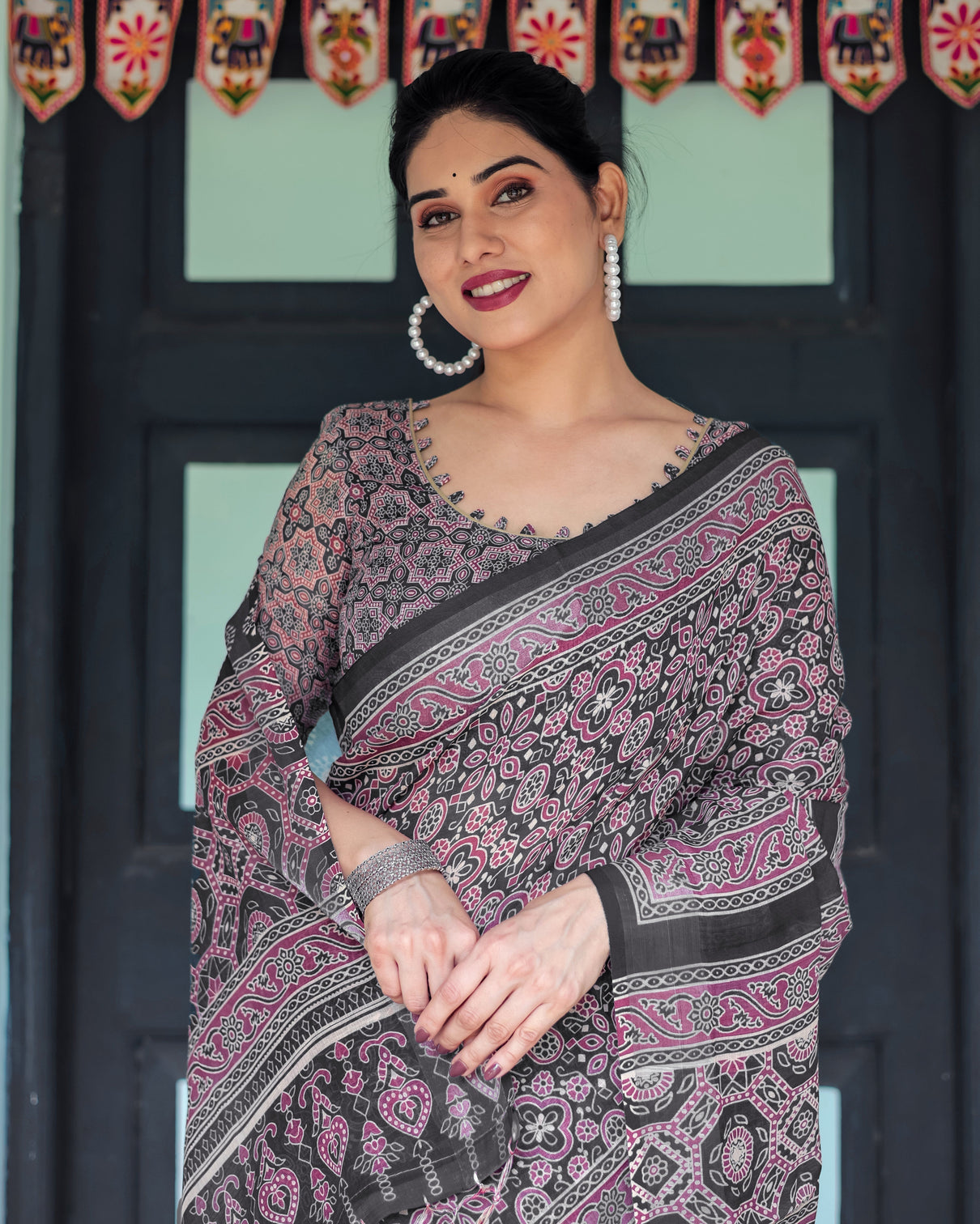 Black pure cotton linen saree with pink striped pallu and tassel accents