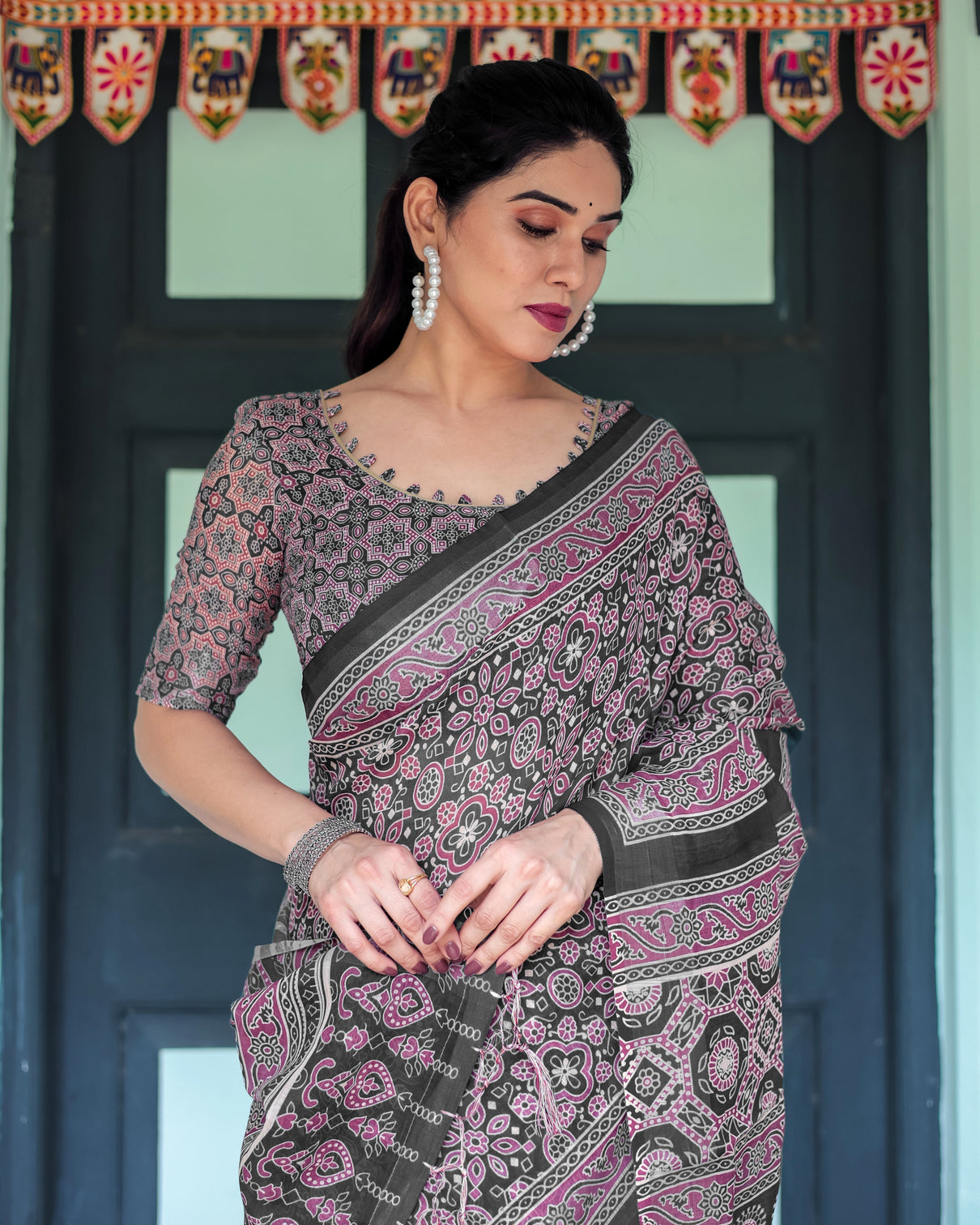 Black pure cotton linen saree with pink striped pallu and tassel accents