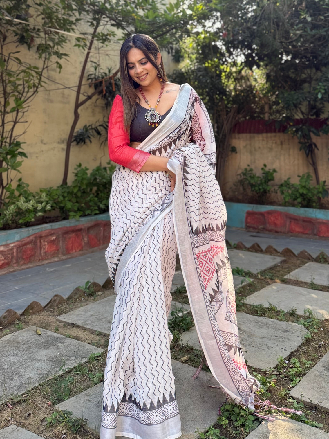 Elegant white pure linen digital printed saree with chevron design and intricate red black geometric pallu tassel details and matching blouse piece mameraa