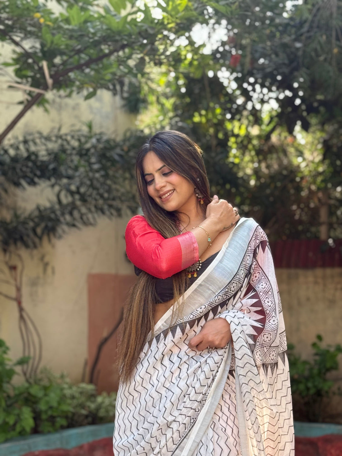 Elegant white pure linen digital printed saree with chevron design and intricate red black geometric pallu tassel details and matching blouse piece