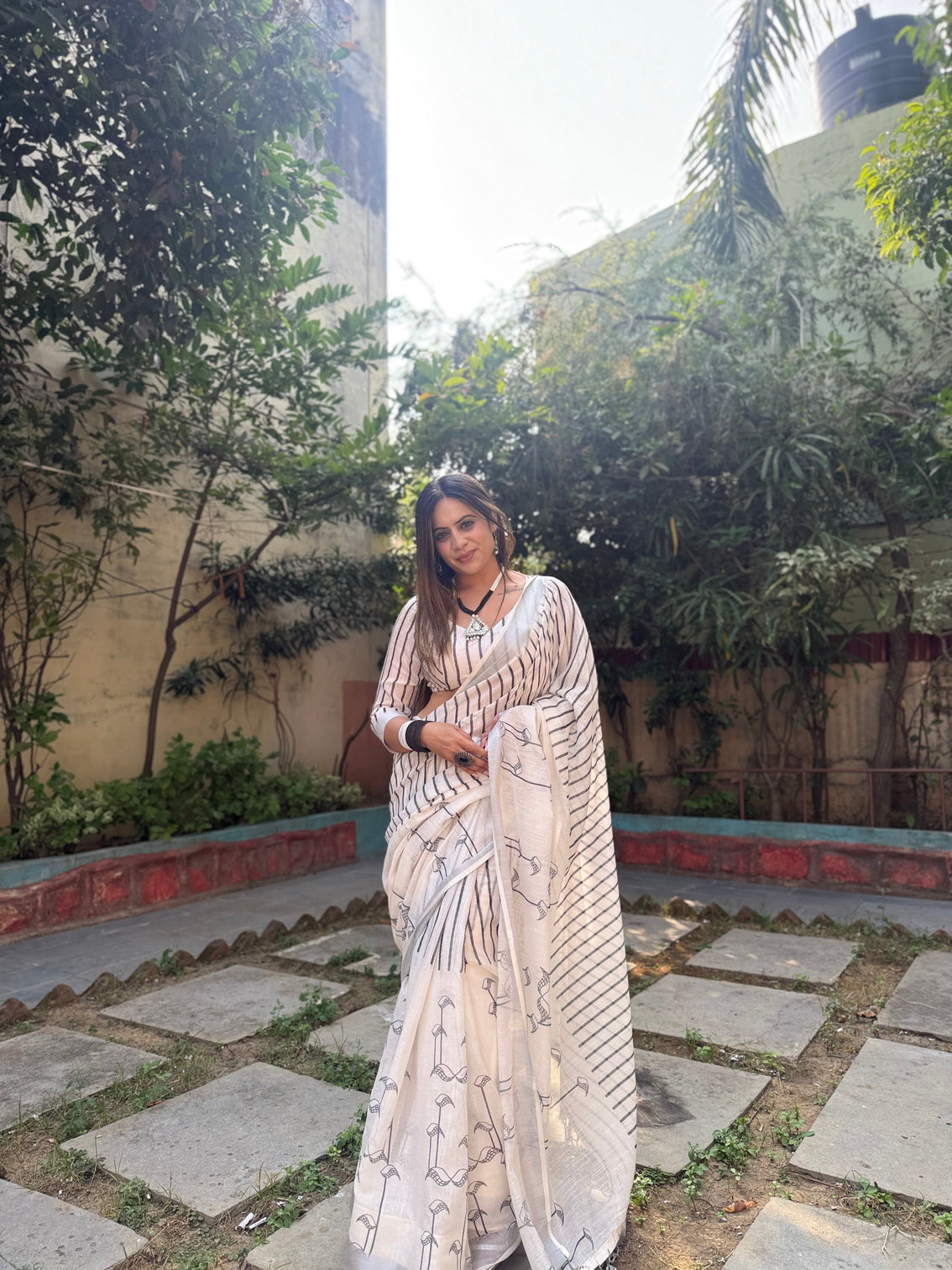 Elegant off white pure linen digital printed saree with striped design and unique black motif pallu comes with blouse piece and tassels