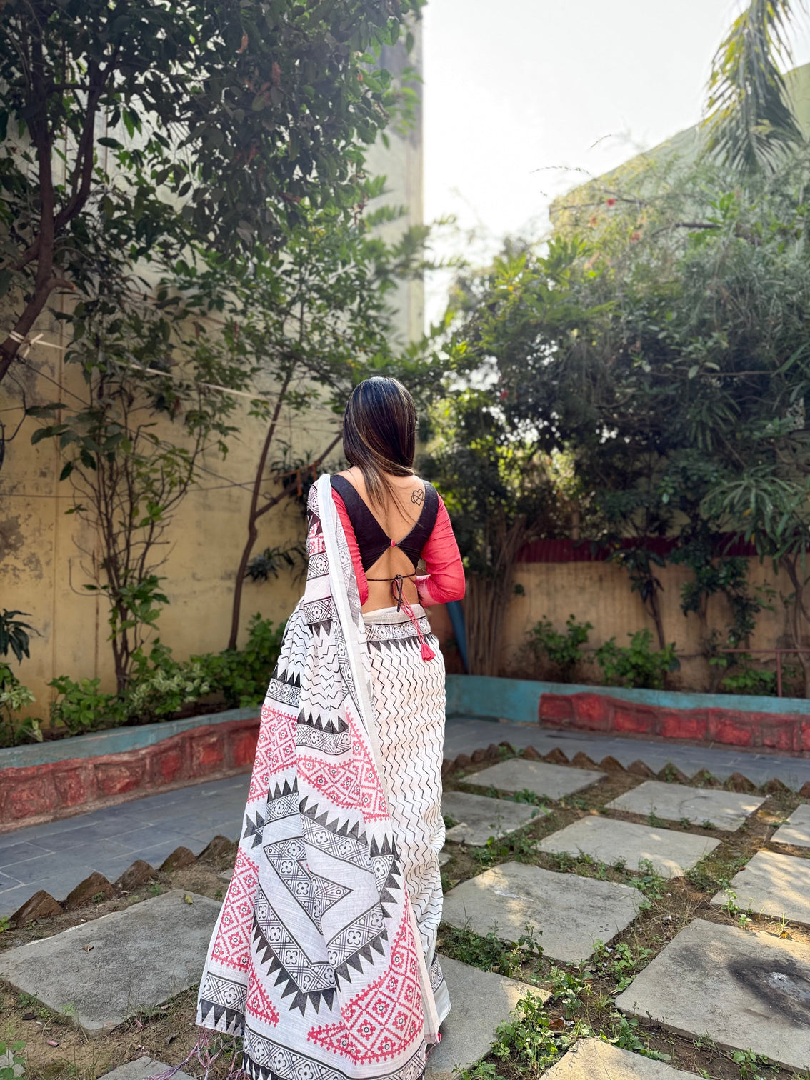 Elegant white pure linen digital printed saree with chevron design and intricate red black geometric pallu tassel details and matching blouse piece
