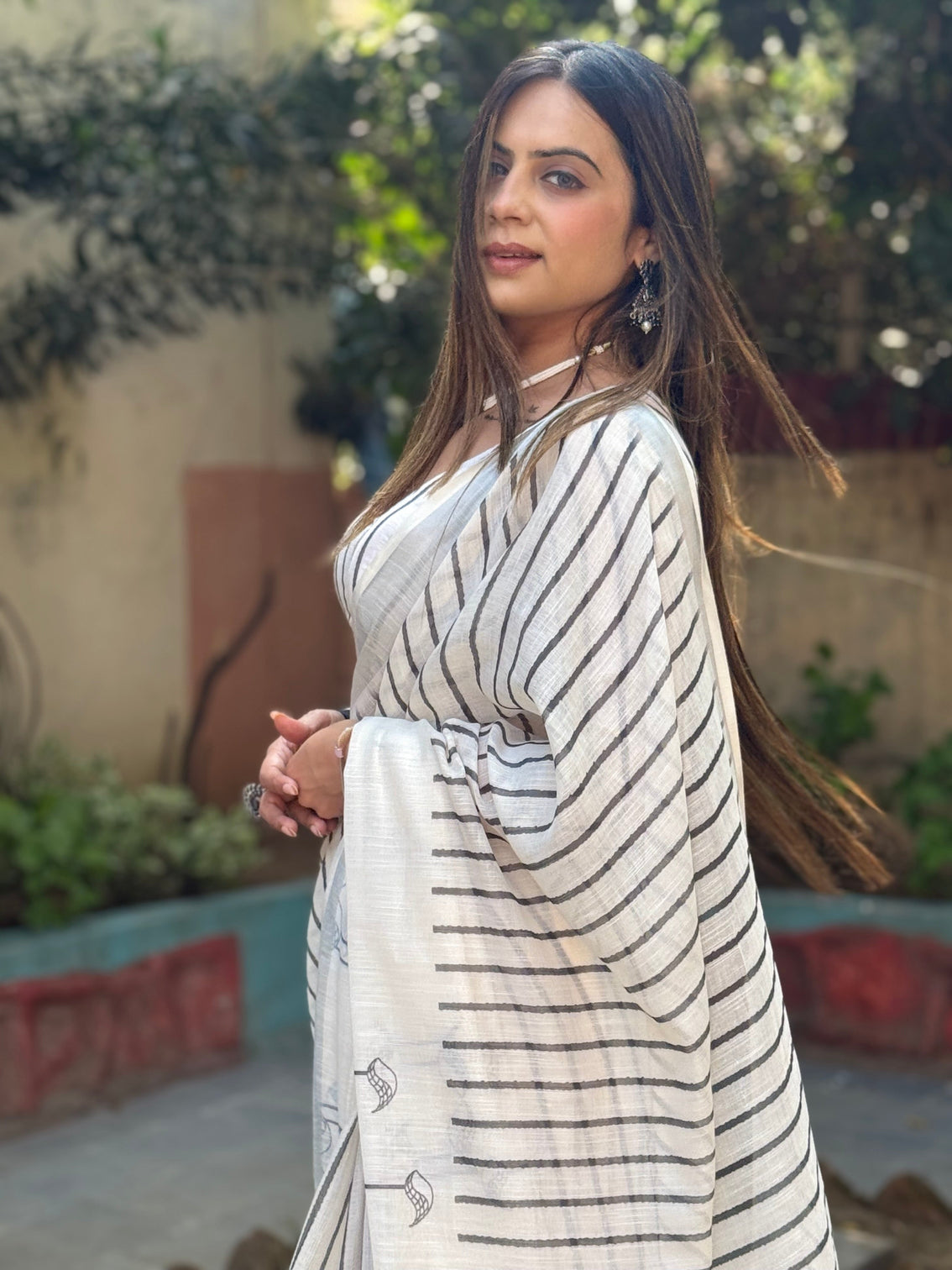 Elegant off white pure linen digital printed saree with striped design and unique black motif pallu comes with blouse piece and tassels