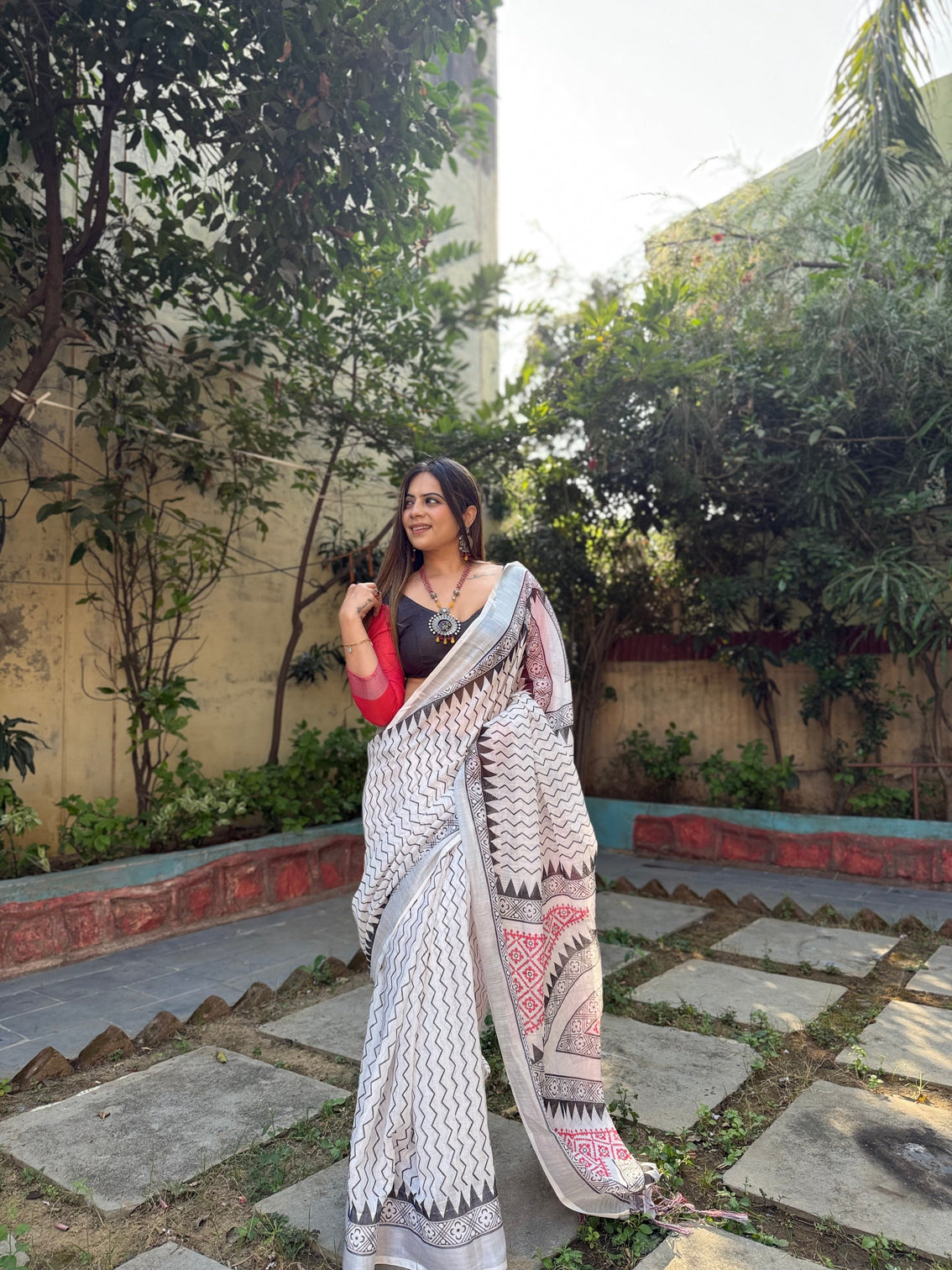 Elegant white pure linen digital printed saree with chevron design and intricate red black geometric pallu tassel details and matching blouse piece