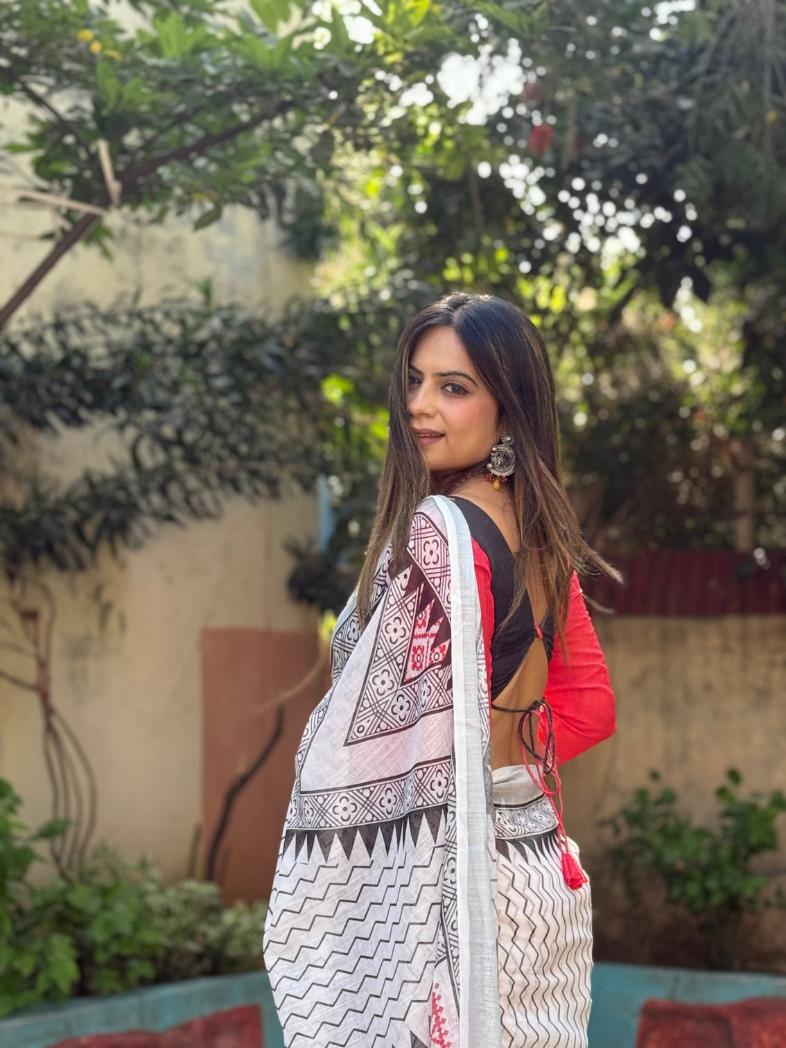 Elegant white pure linen digital printed saree with chevron design and intricate red black geometric pallu tassel details and matching blouse piece