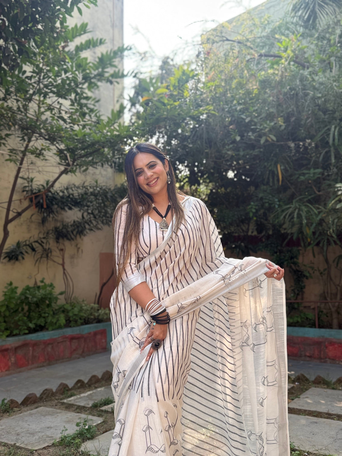 Elegant off white pure linen digital printed saree with striped design and unique black motif pallu comes with blouse piece and tassels