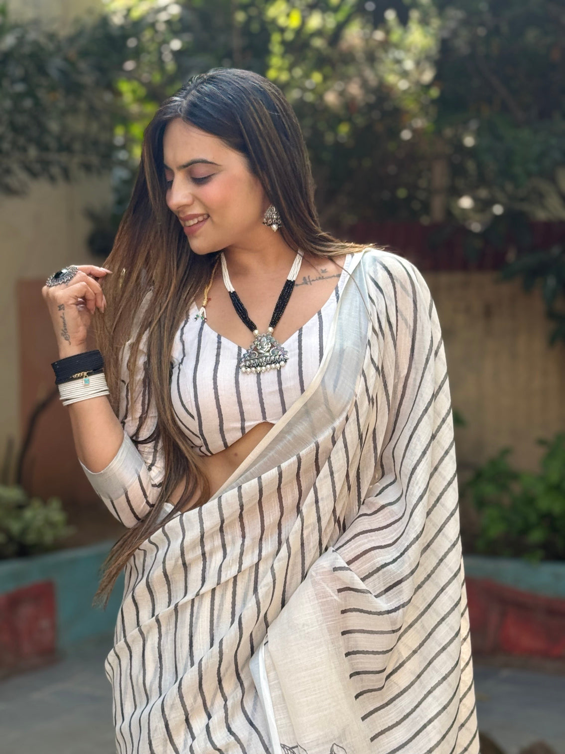 Elegant off white pure linen digital printed saree with striped design and unique black motif pallu comes with blouse piece and tassels