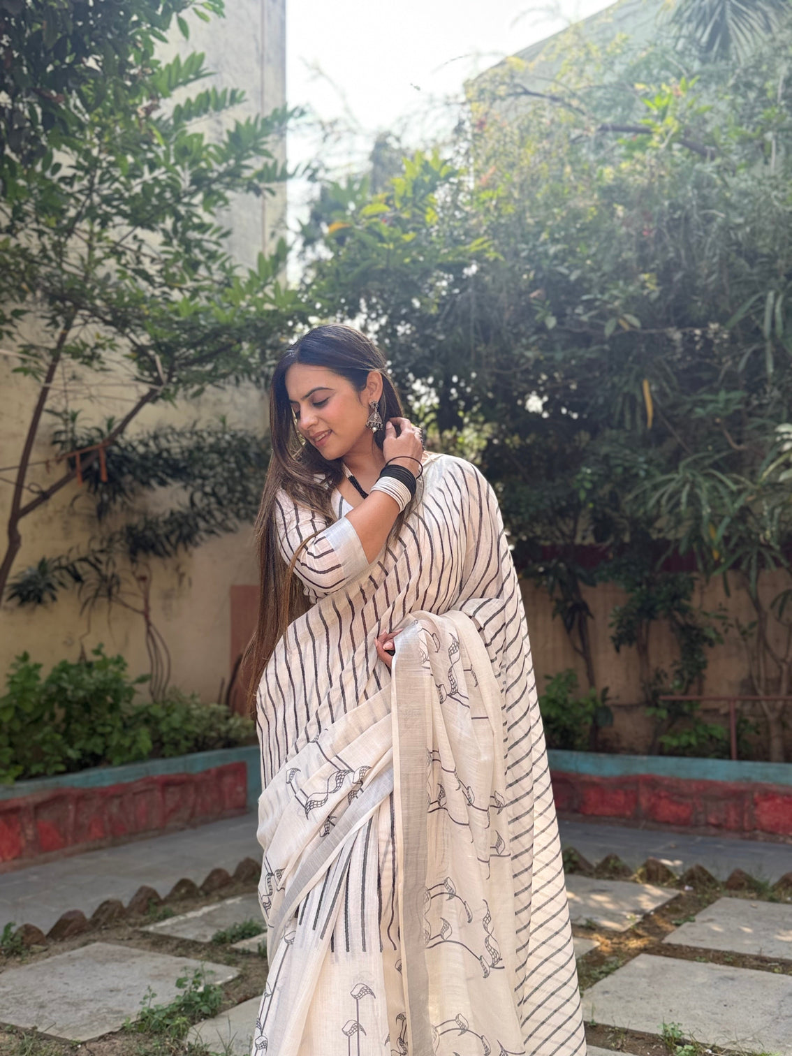Elegant off white pure linen digital printed saree with striped design and unique black motif pallu comes with blouse piece and tassels