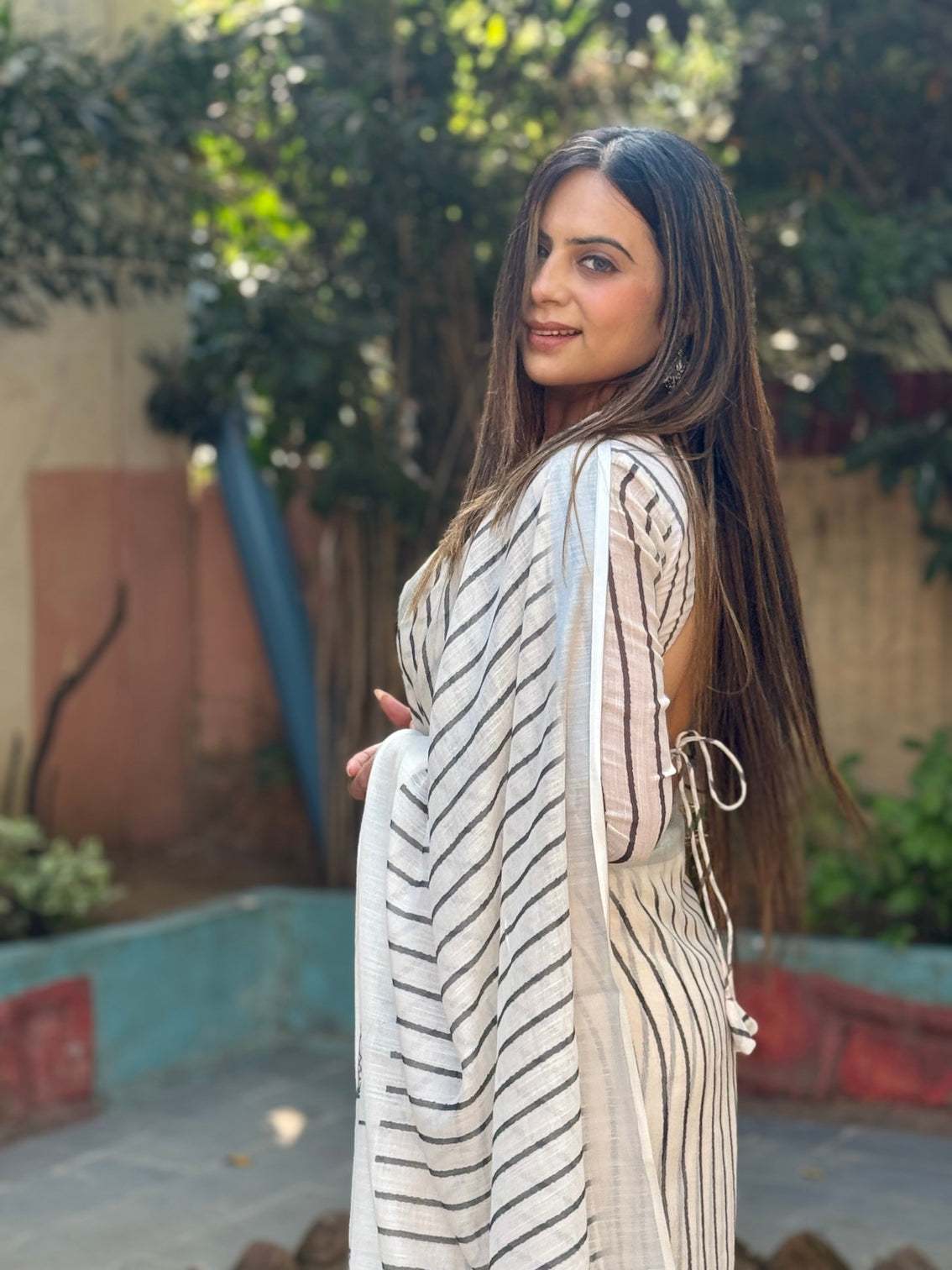 Elegant off white pure linen digital printed saree with striped design and unique black motif pallu comes with blouse piece and tassels