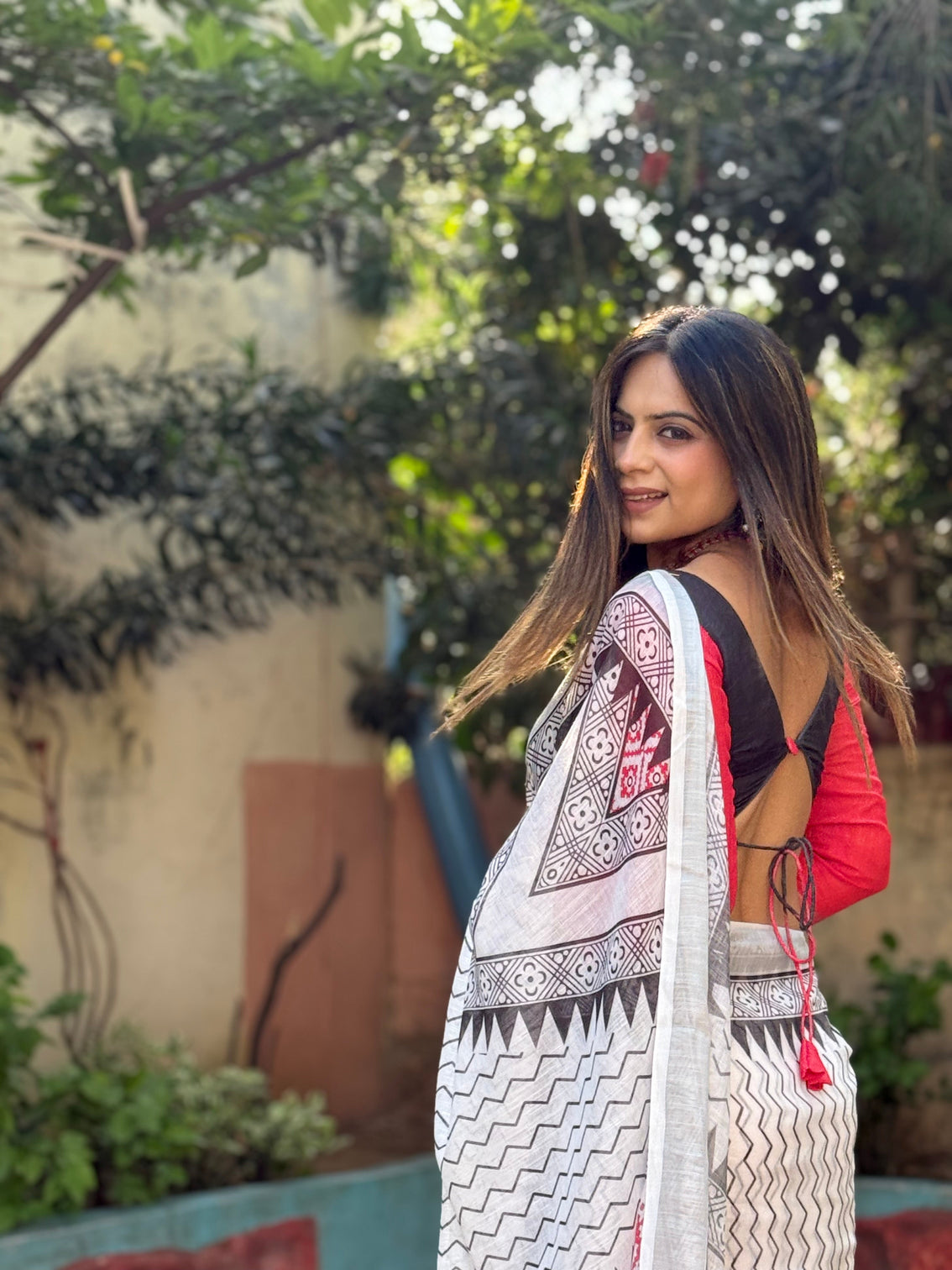 Elegant white pure linen digital printed saree with chevron design and intricate red black geometric pallu tassel details and matching blouse piece