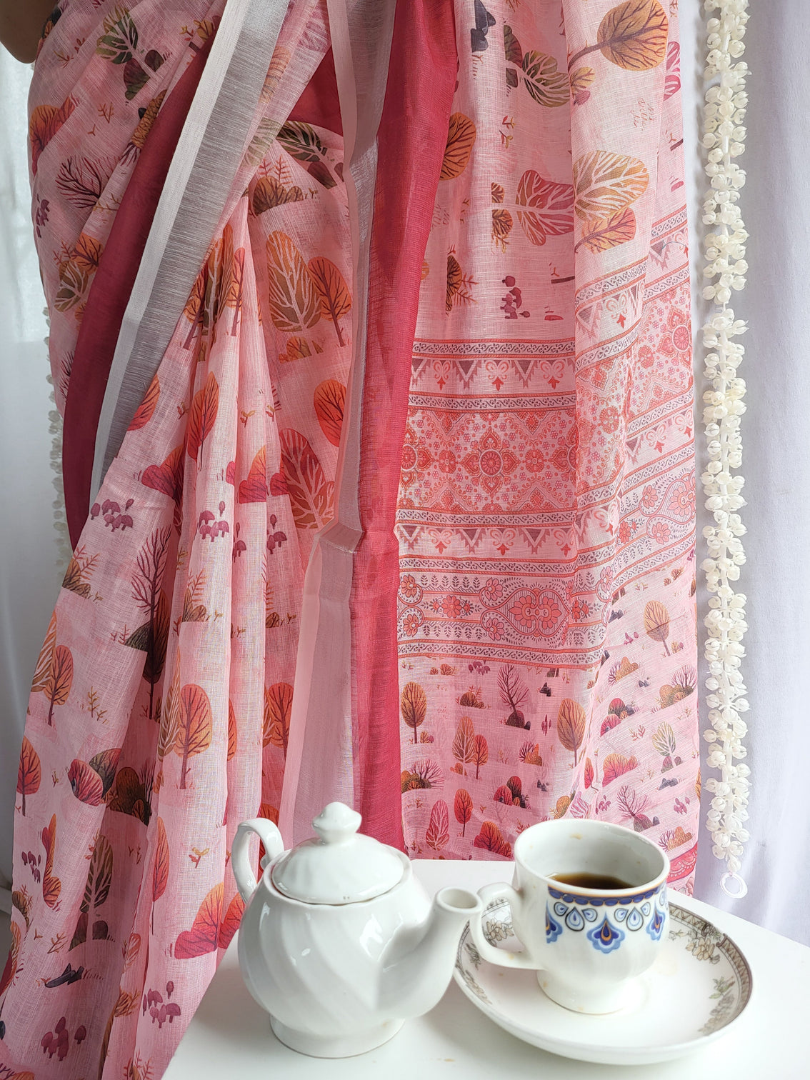 Blush pink handwoven linen saree with vibrant autumn motifs tassel detailing