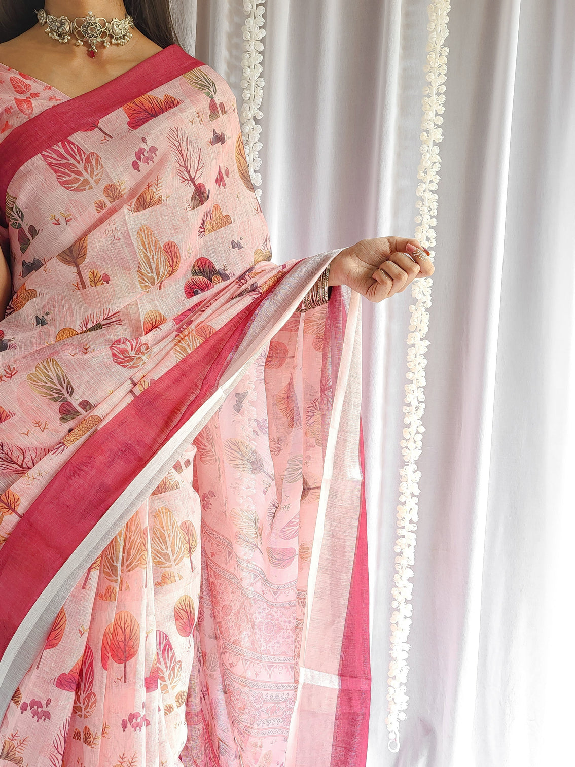 Blush pink handwoven linen saree with vibrant autumn motifs tassel detailing