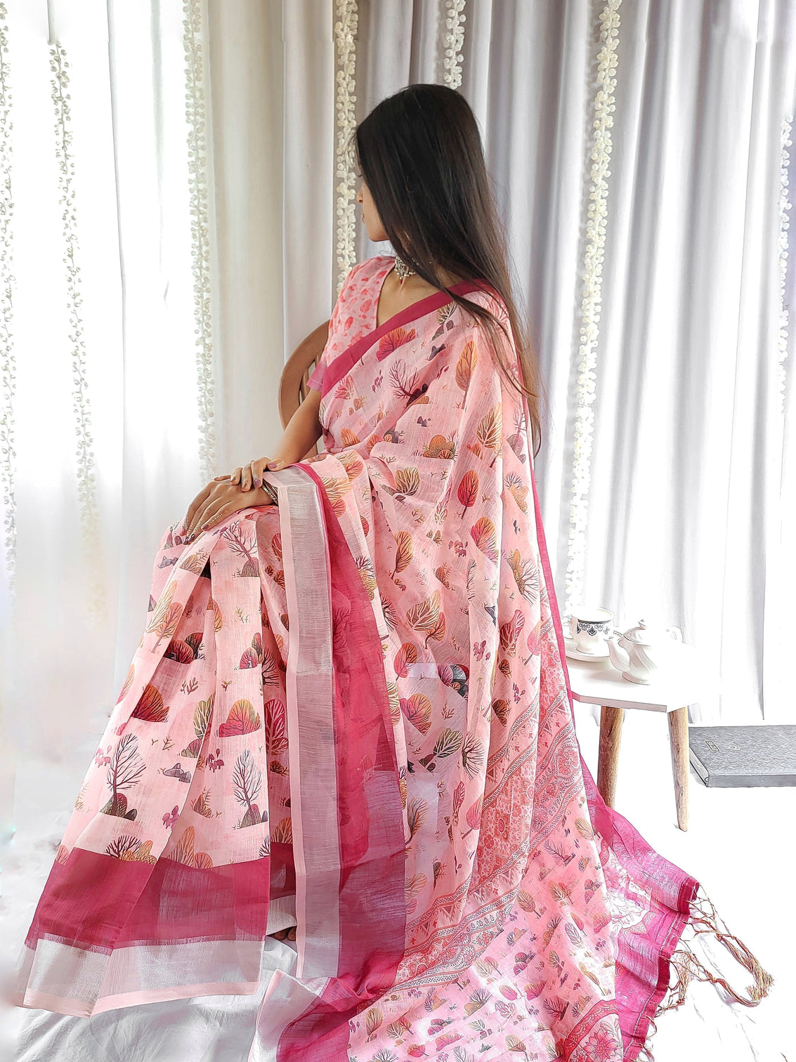 Blush pink handwoven linen saree with vibrant autumn motifs tassel detailing