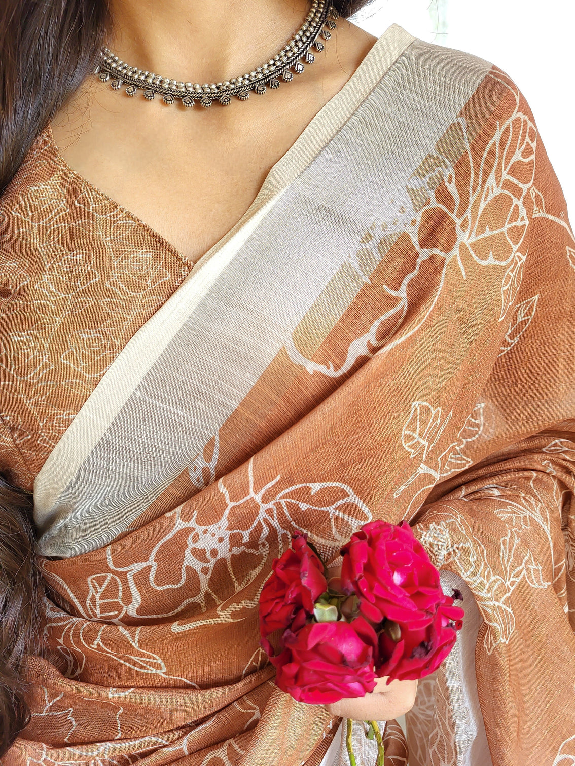 Rust brown pure linen saree with white floral motifs and tassel detailing