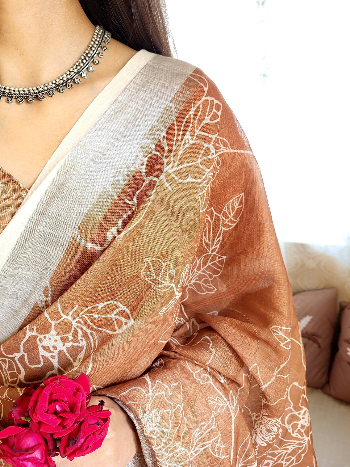 Rust brown pure linen saree with white floral motifs and tassel detailing