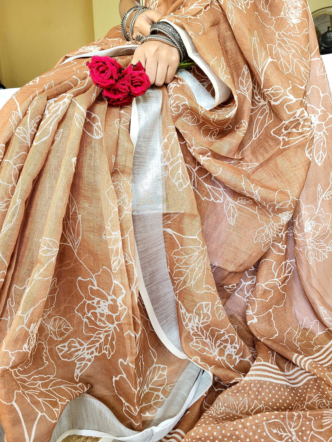 Rust brown pure linen saree with white floral motifs and tassel detailing