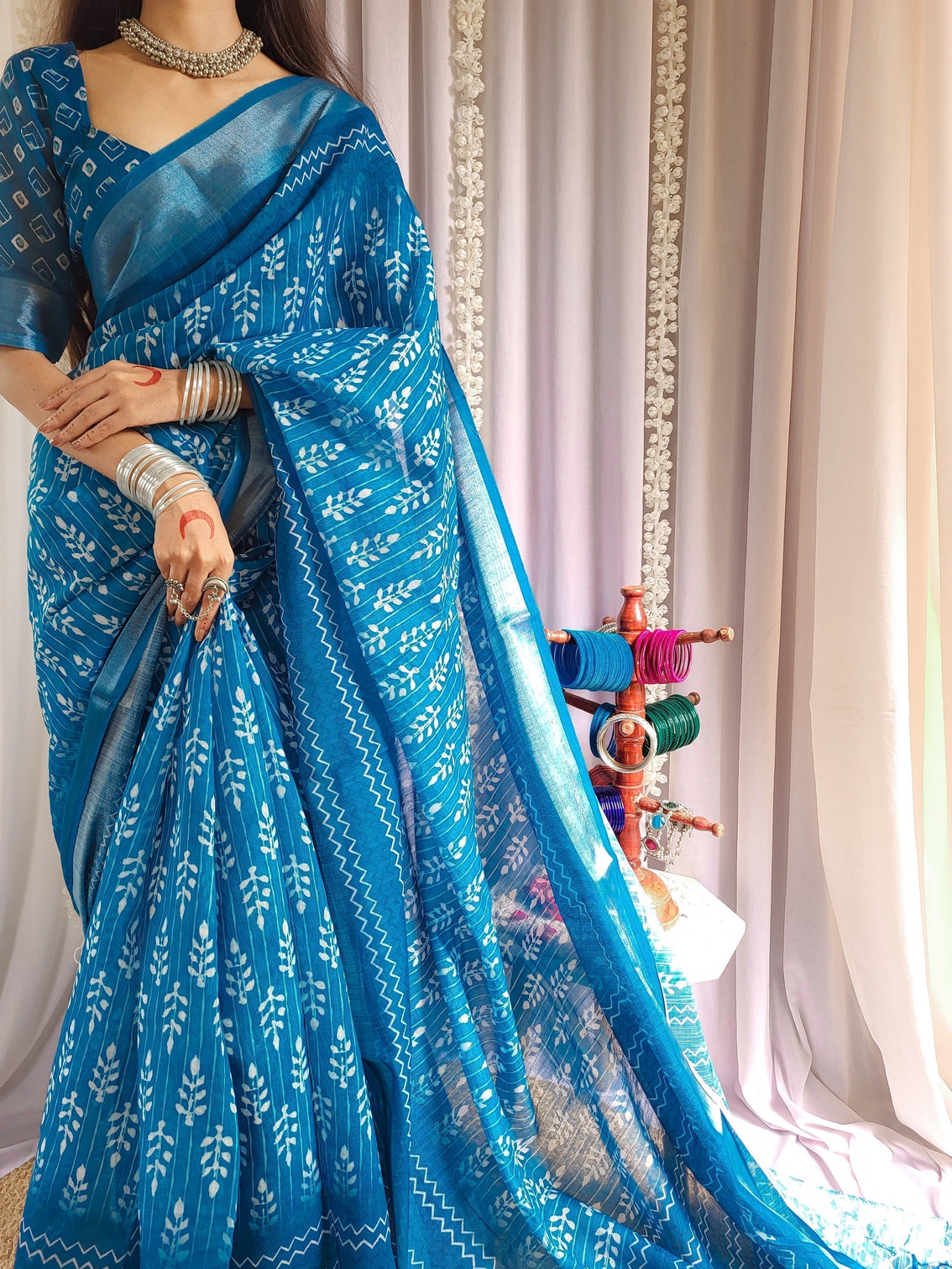 Elegant blue pure linen saree with tassels and white floral patterns