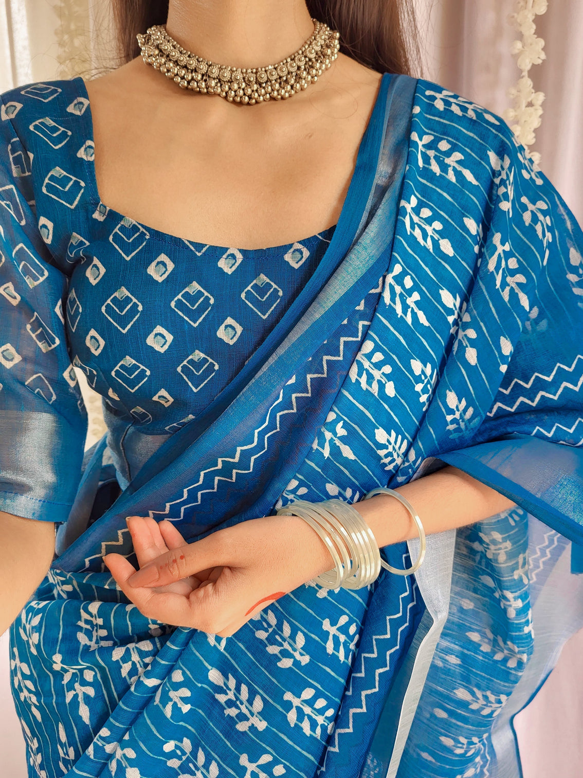Elegant blue pure linen saree with tassels and white floral patterns