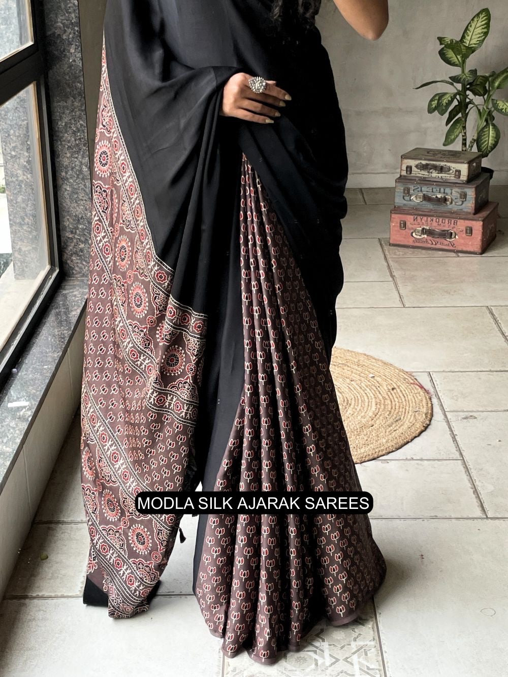 Black modal silk ajrakh printed saree with traditional heritage pallu intricate ethnic motifs tassel detailing