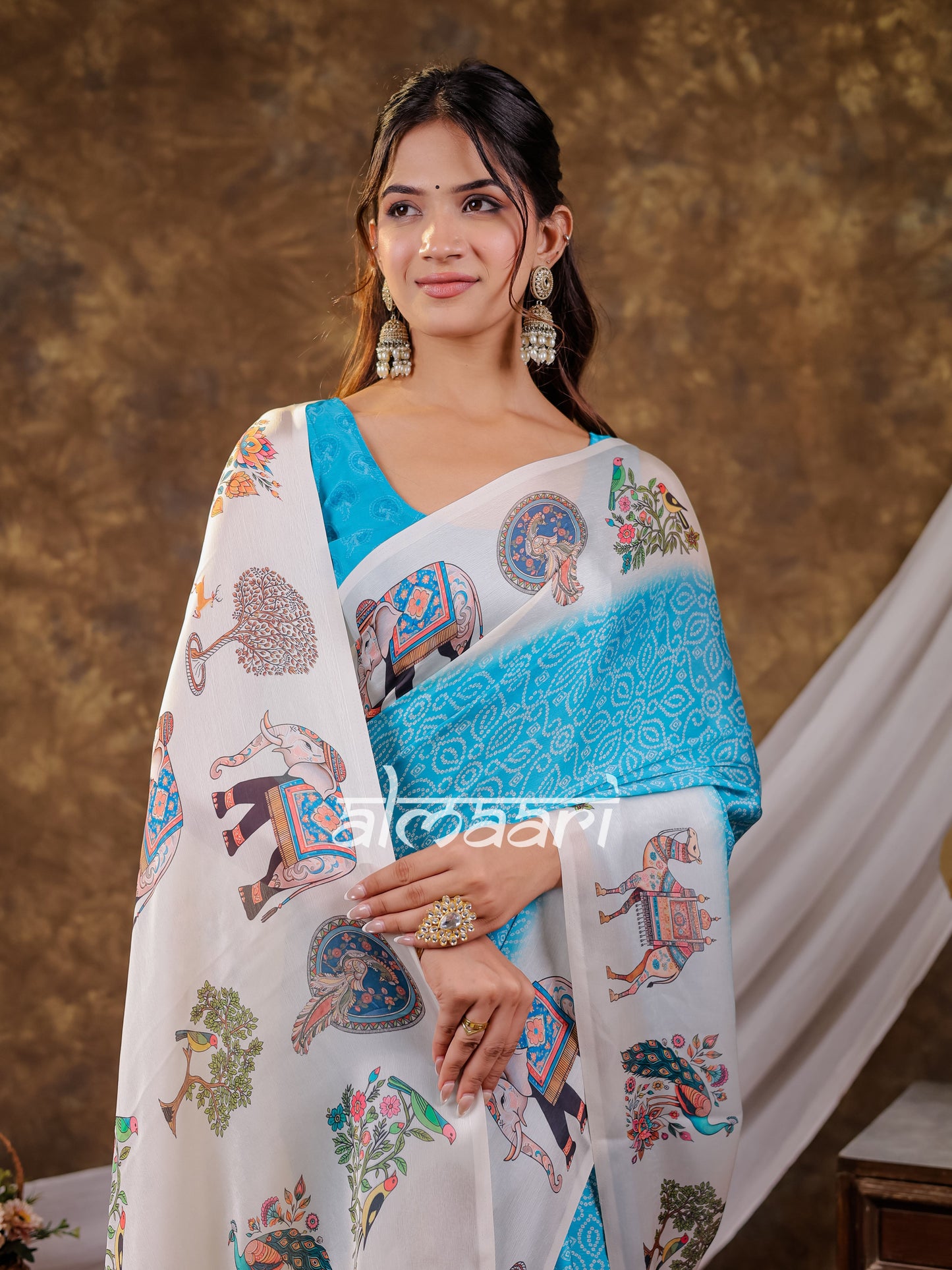 Vantara Turquoise Blue Satin Chiffon Printed Saree with Elephant & Peacock Heritage Print, Designer Tassel Pallu & Matching Blouse Piece