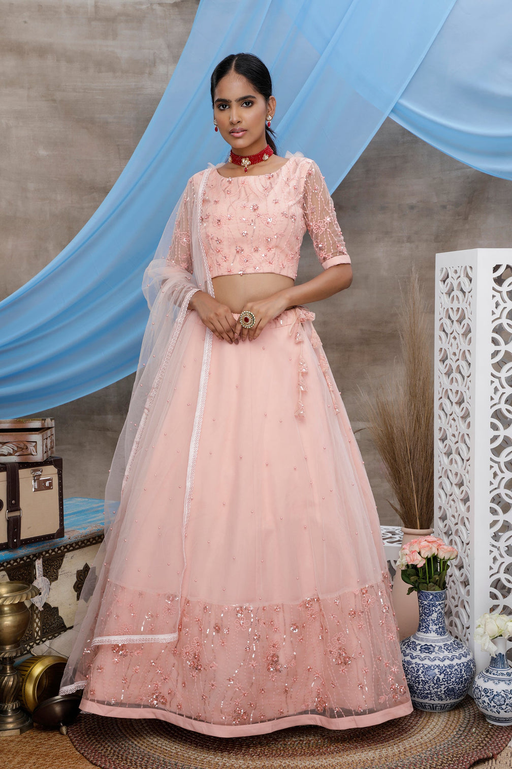 Peach Thread And Sequence Embroidered With All Over Pearl Rivet Stud Pasting Net Semi Stitched Bridal Lehenga