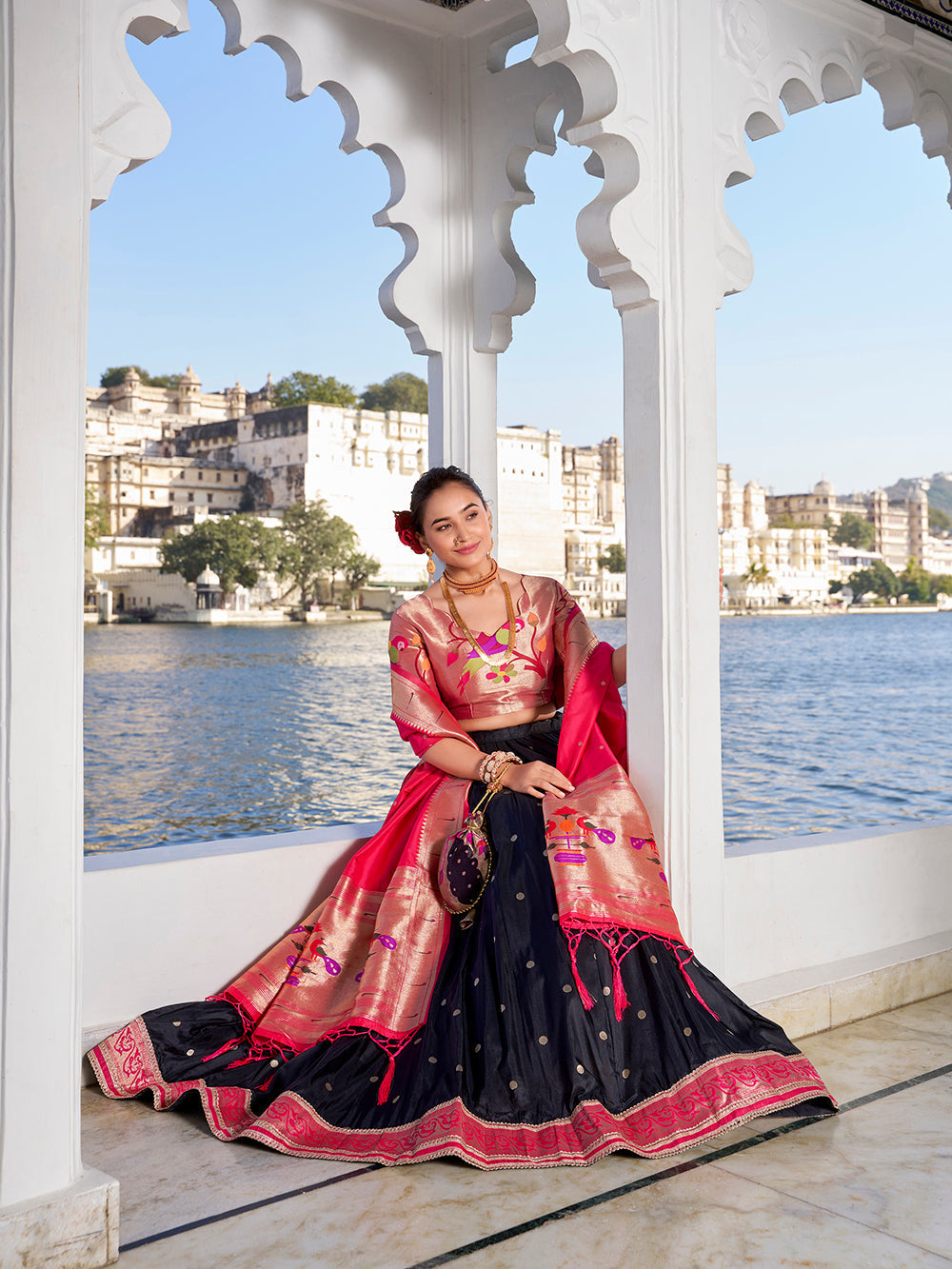 Elegant black jacquard silk lehenga choli with zari weaving matching potli purse