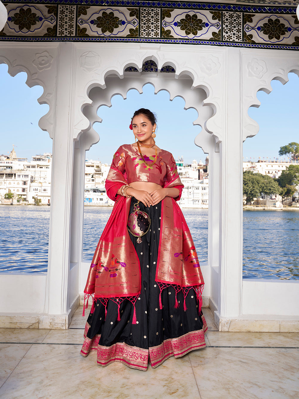 Elegant black jacquard silk lehenga choli with zari weaving matching potli purse